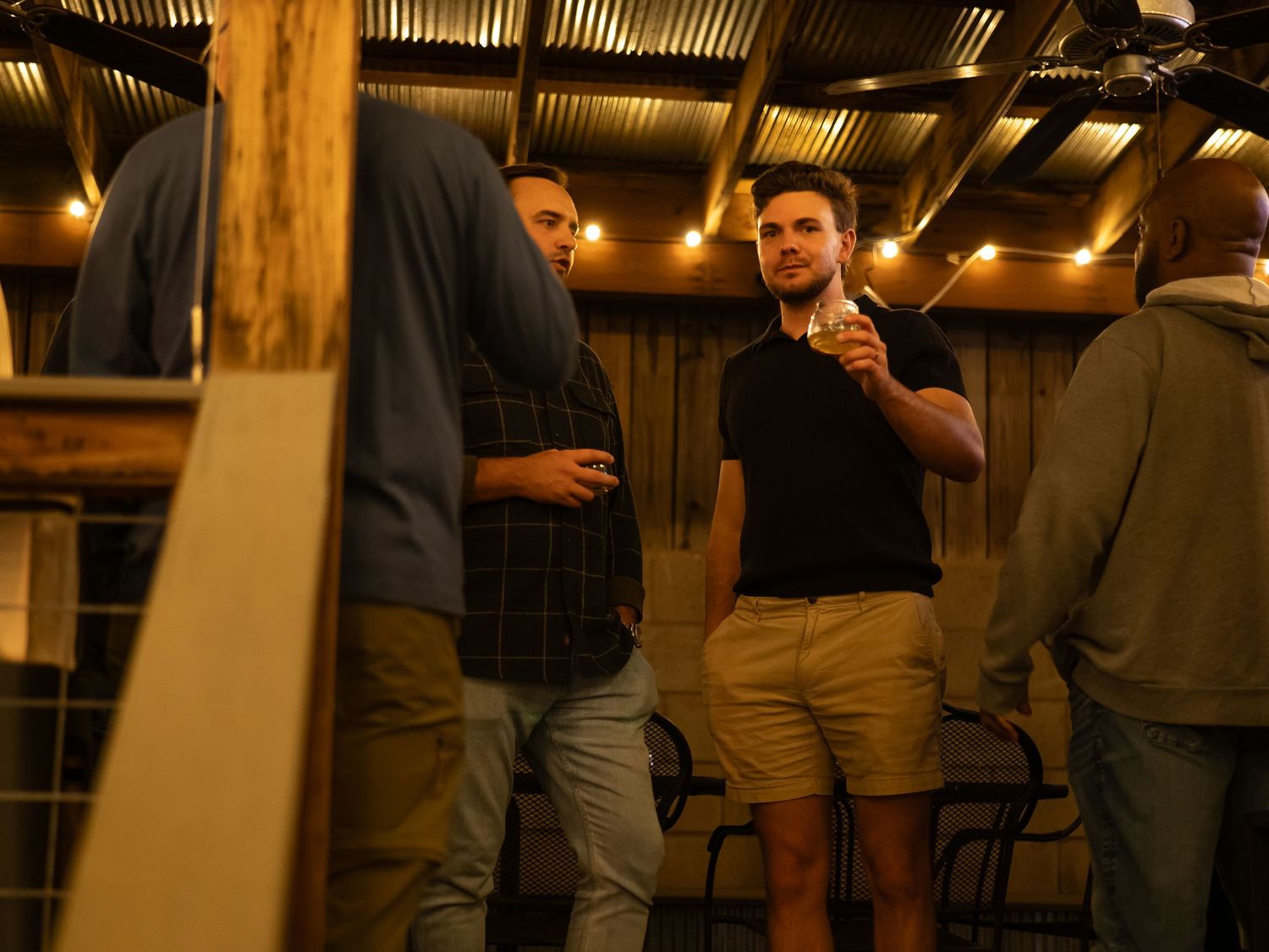 People gathered in a dimly lit indoor venue with warm ambient lighting creating a cozy atmosphere.