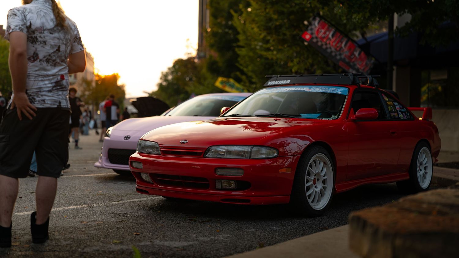 Car meet featuring modified Japanese sports cars with custom paint and body modifications.