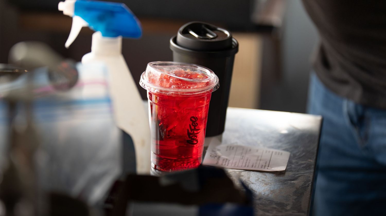 Colorful beverage cups lined up on a dark counter surface.
