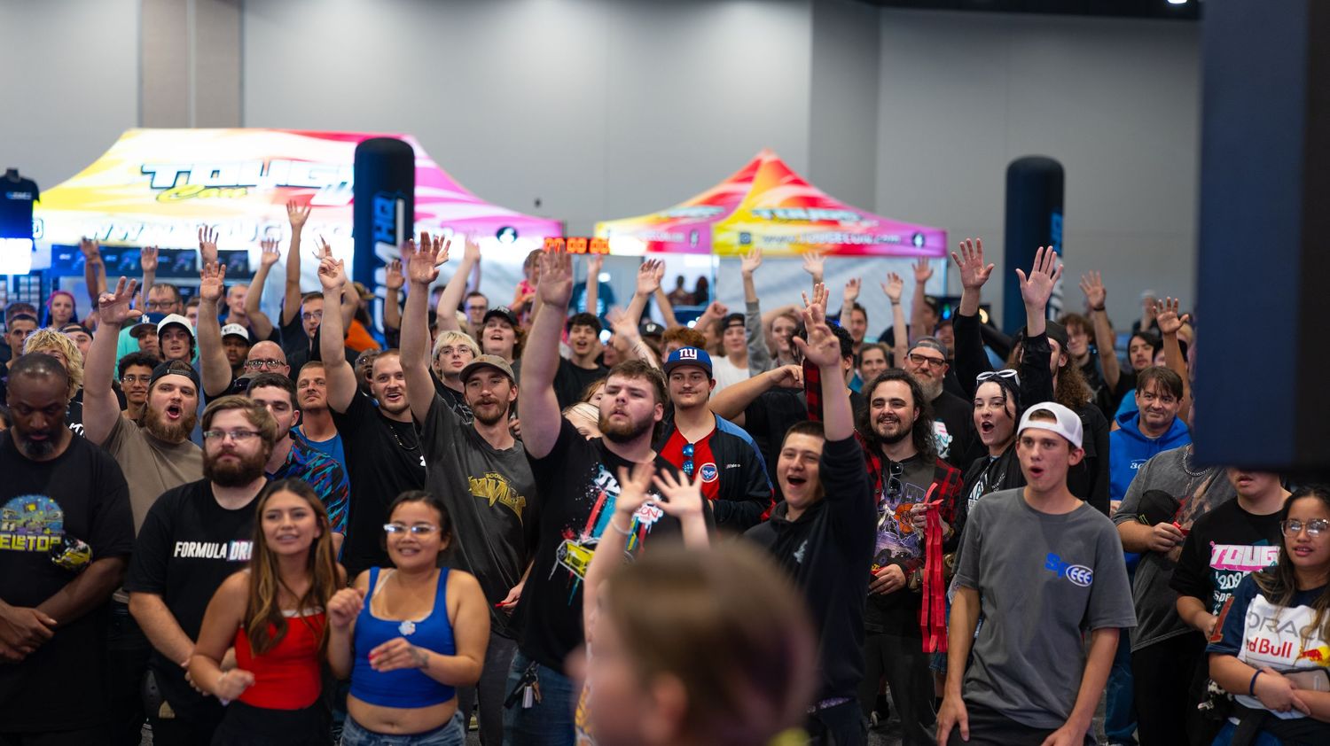 Gaming convention hall with colorful vendor tents and packed audience.