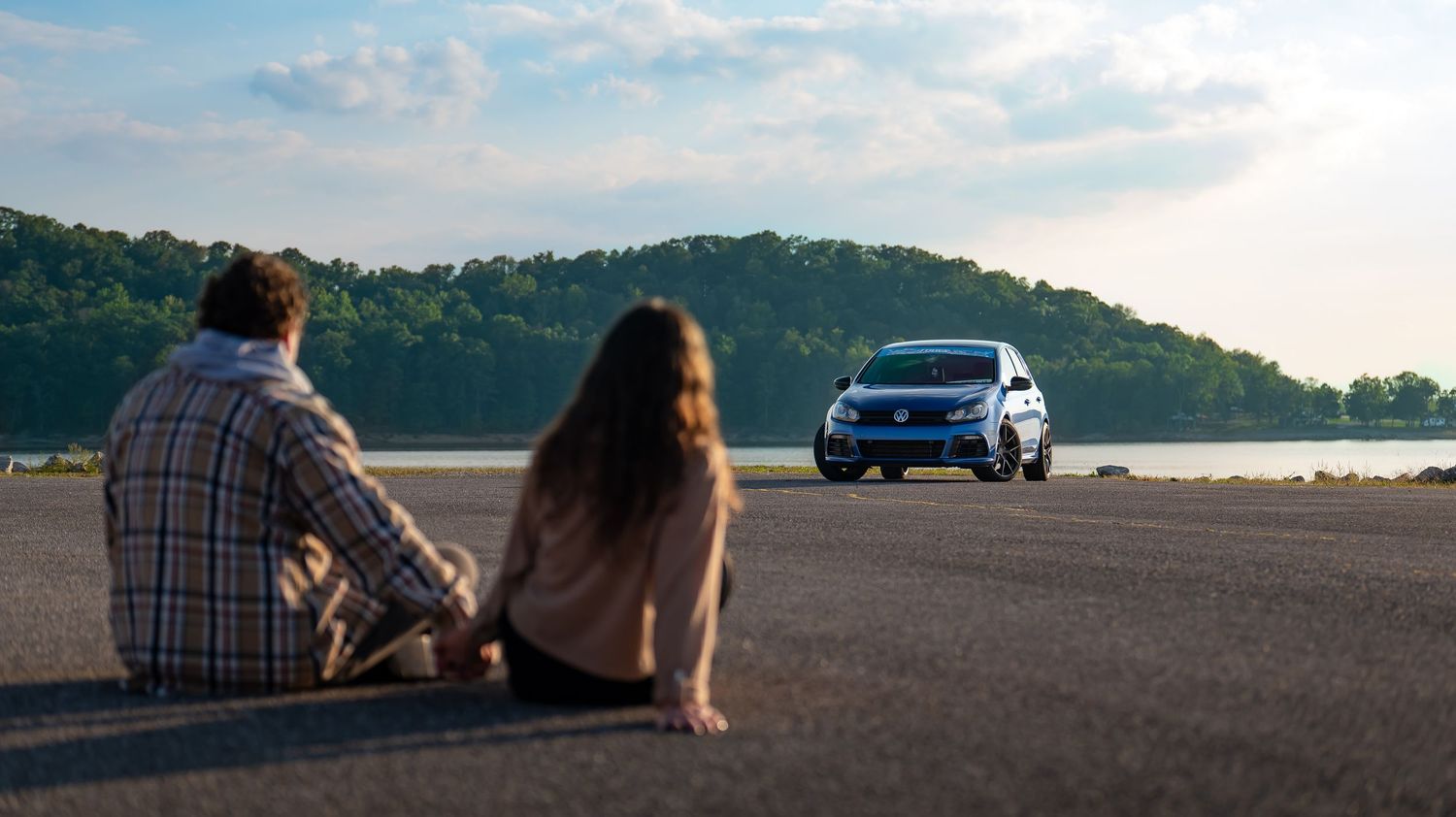 Scenic landscape view of mountains and sky with a car visible in the distance.