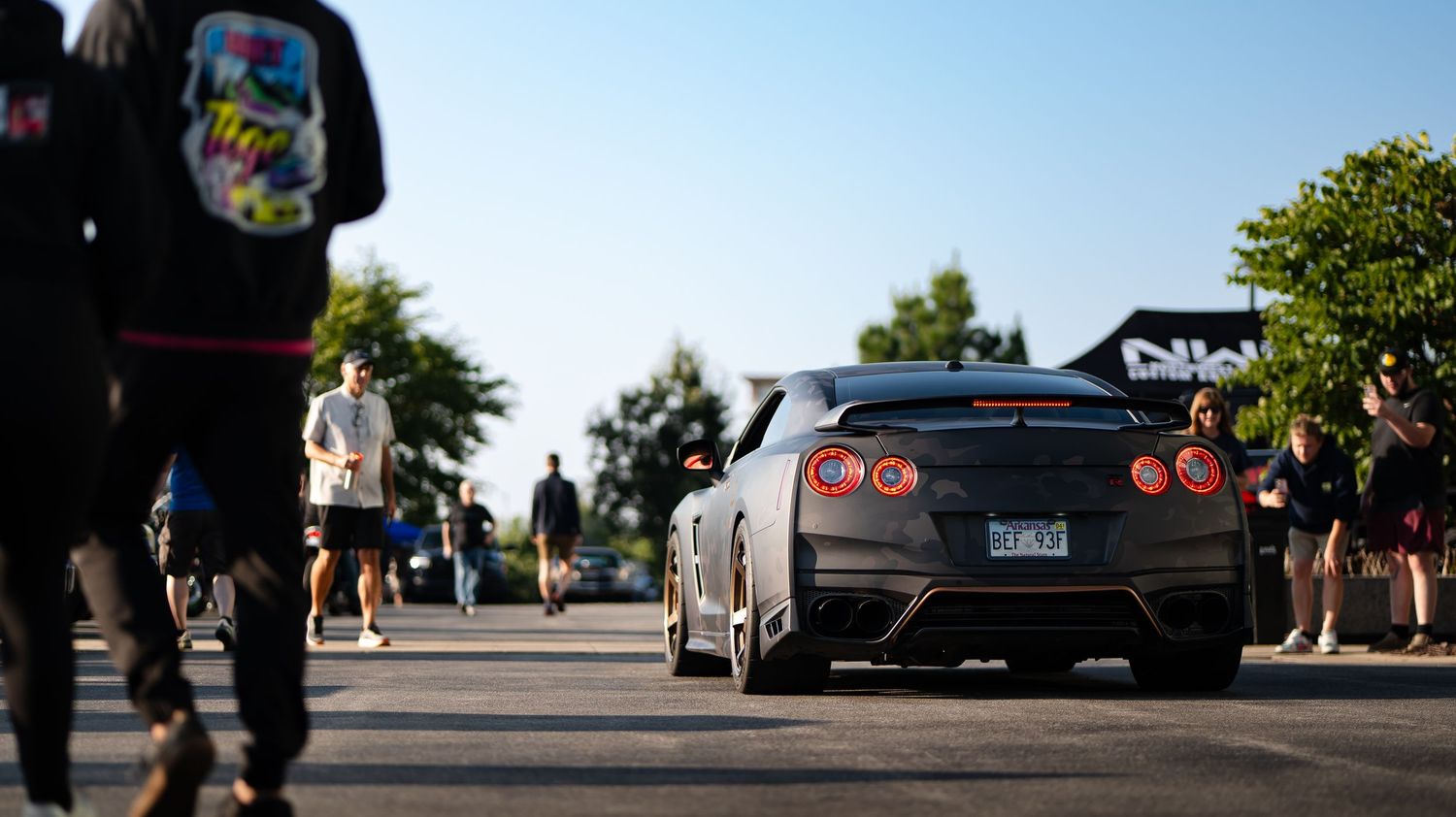 Line of exotic sports cars parked at daytime car show event.