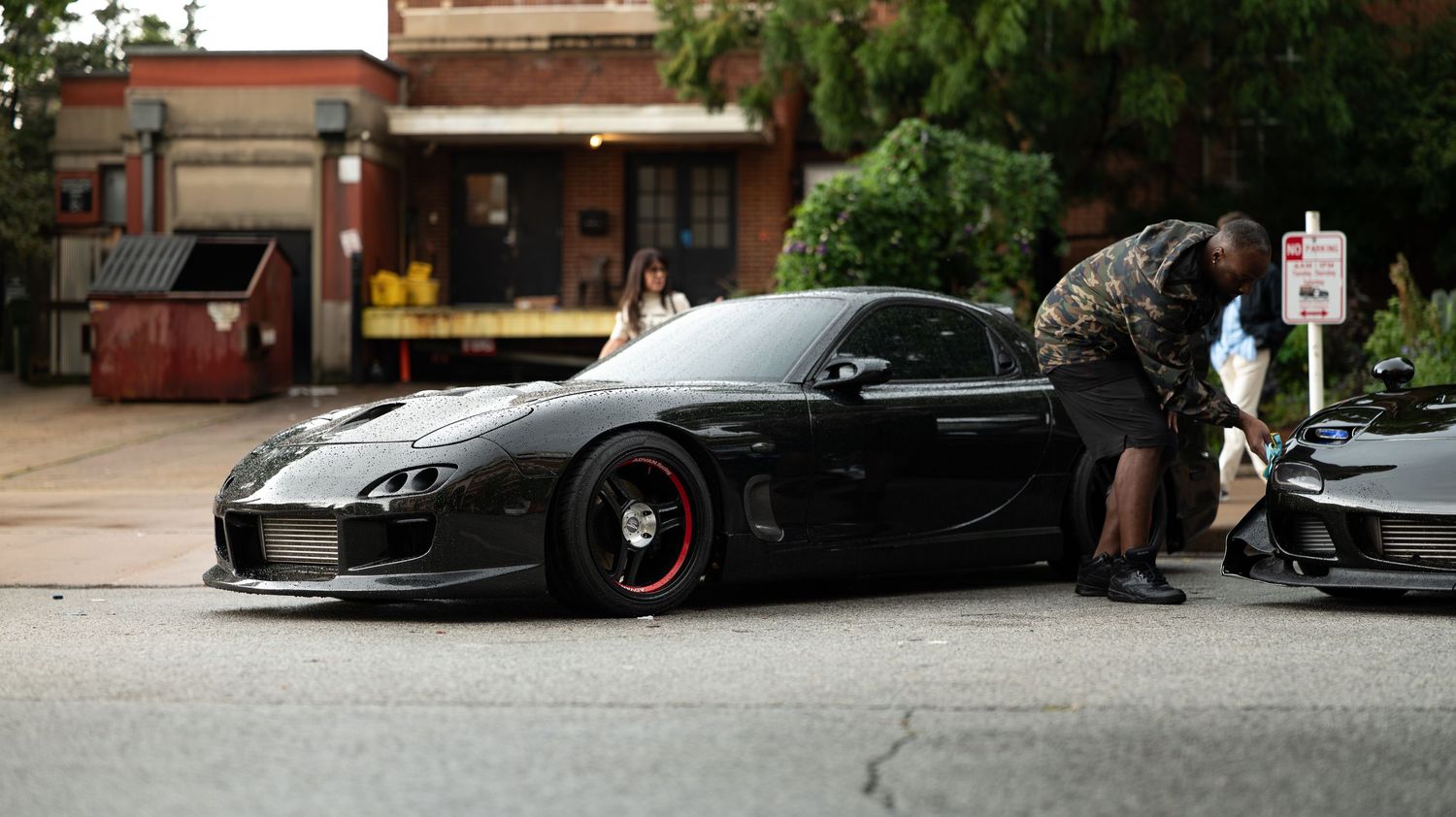 Low-angle view of modified cars parked in an urban setting.