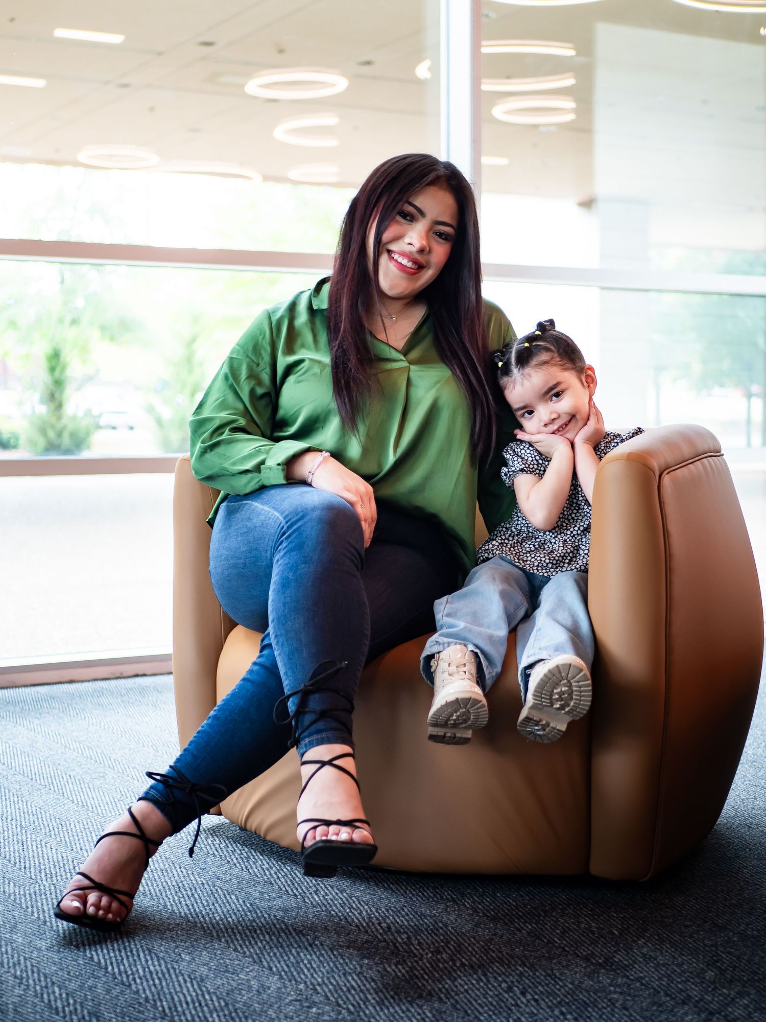 Friends relaxing on brown leather furniture in a bright modern office space.