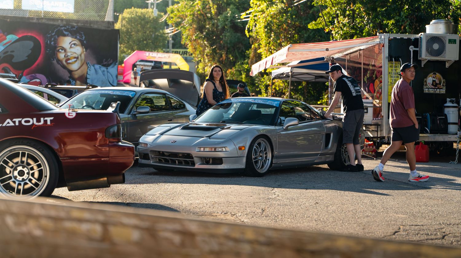 Wide view of cars displayed at an outdoor auto show event.