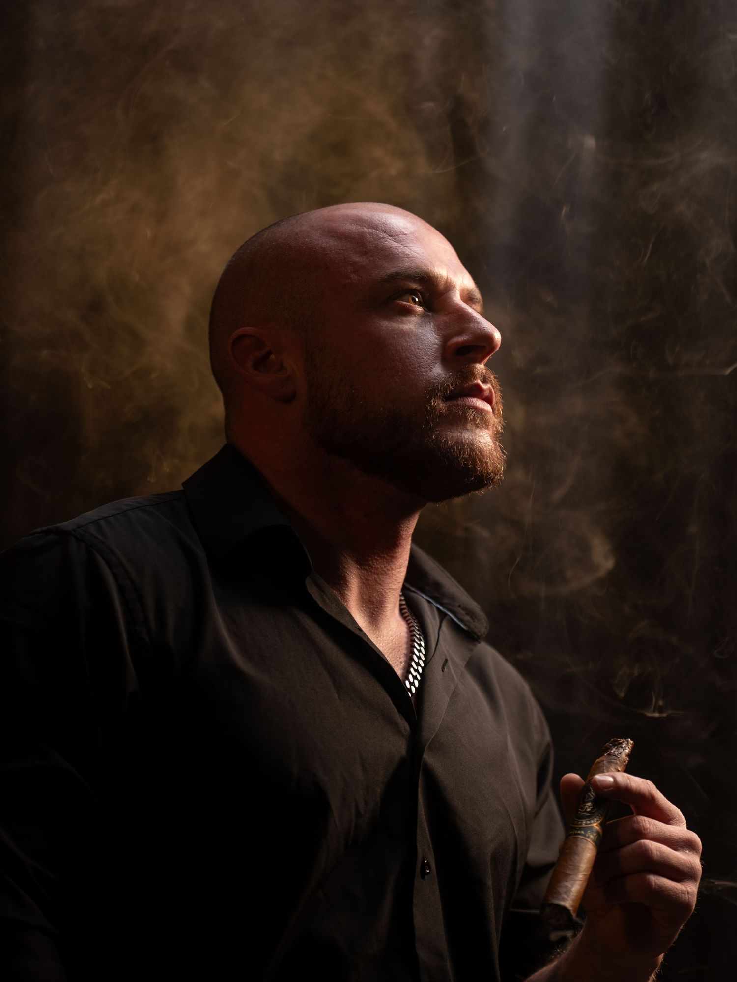 Atmospheric portrait of a person smoking a cigar surrounded by golden smoke in dramatic lighting.