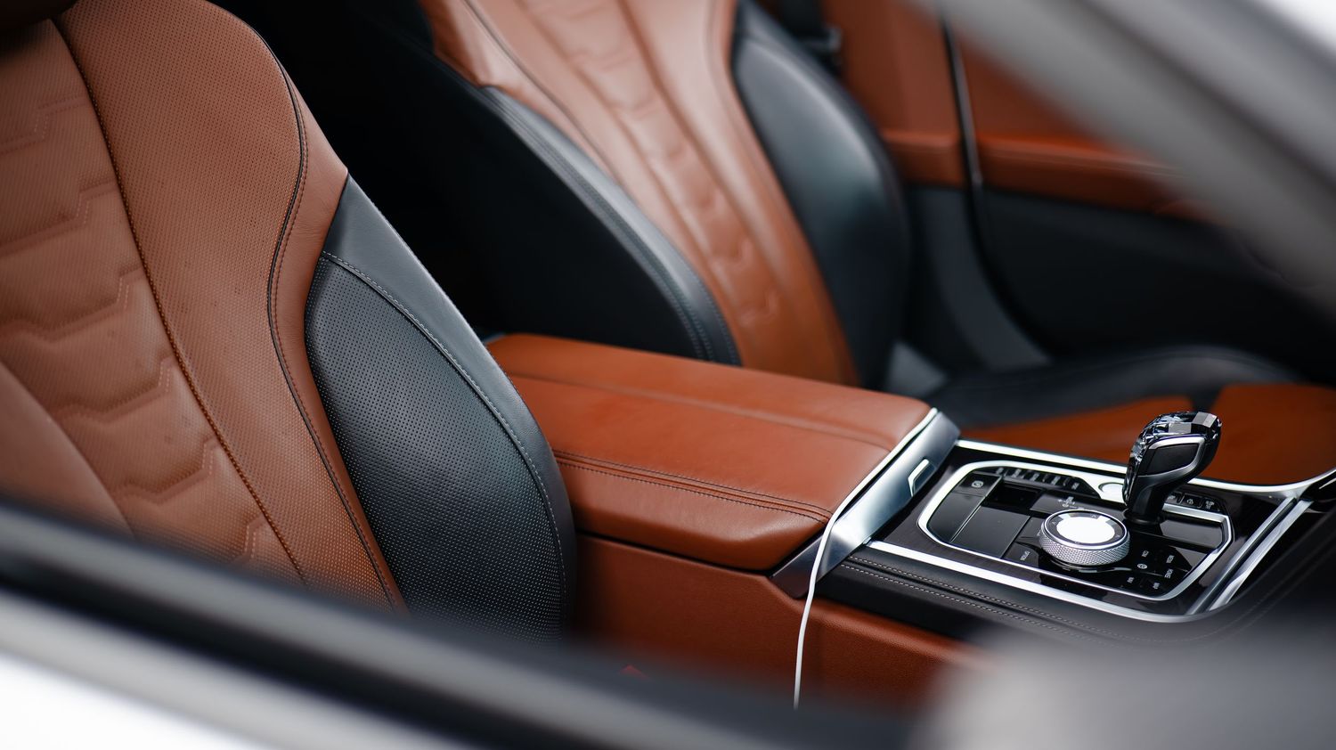 Interior details of a BMW vehicle with brown leather trim and dashboard components.