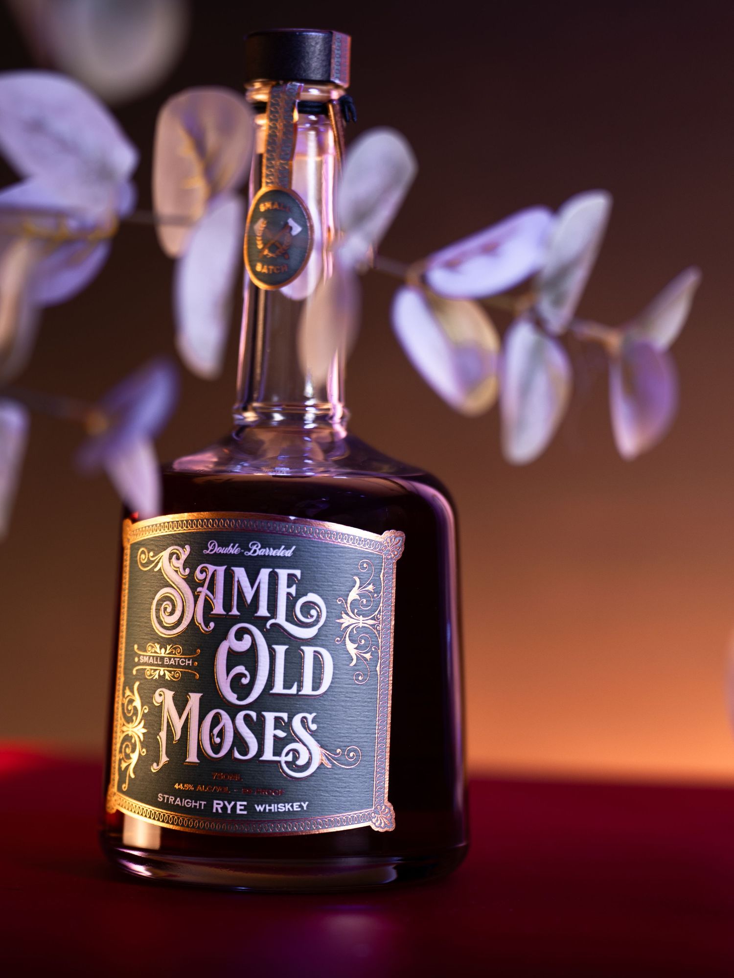 Close-up shots of a dark glass bottle with ornate 'Time Monk' lettering against a moody background with soft bokeh lights.