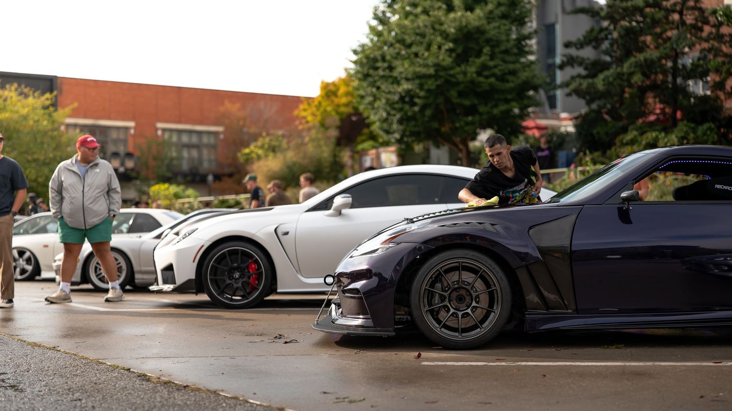 Parking lot filled with various sports cars and performance vehicles.