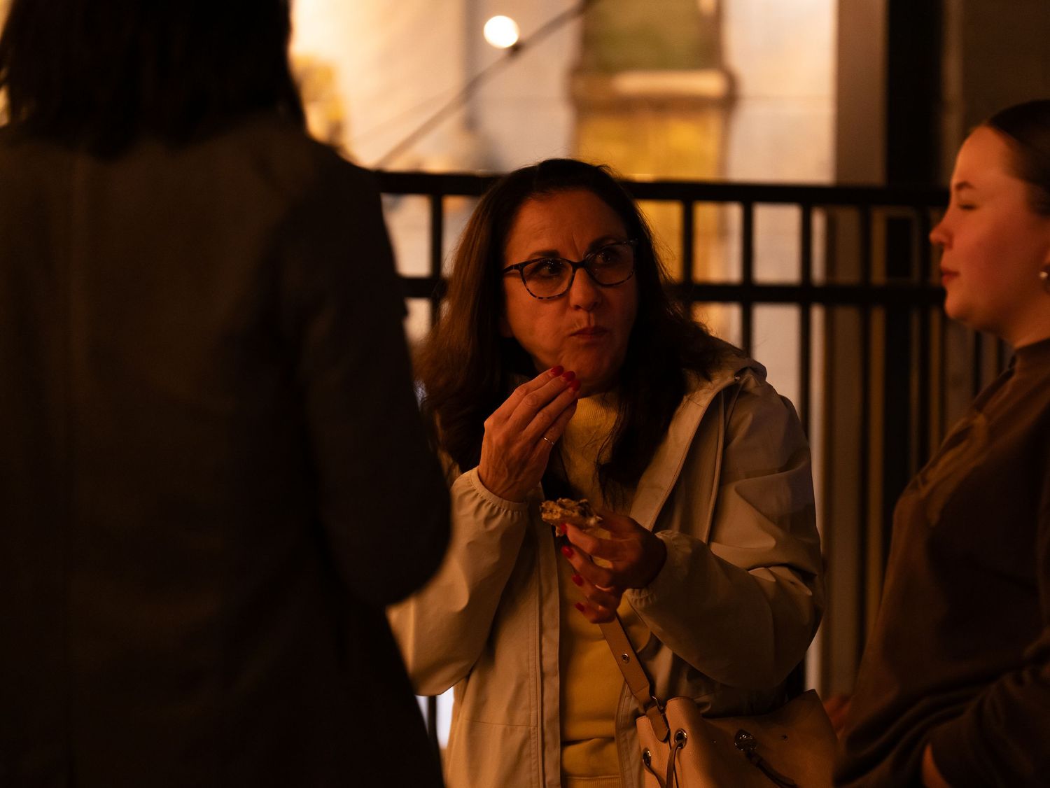 People having a conversation outdoors at night in warm ambient lighting.