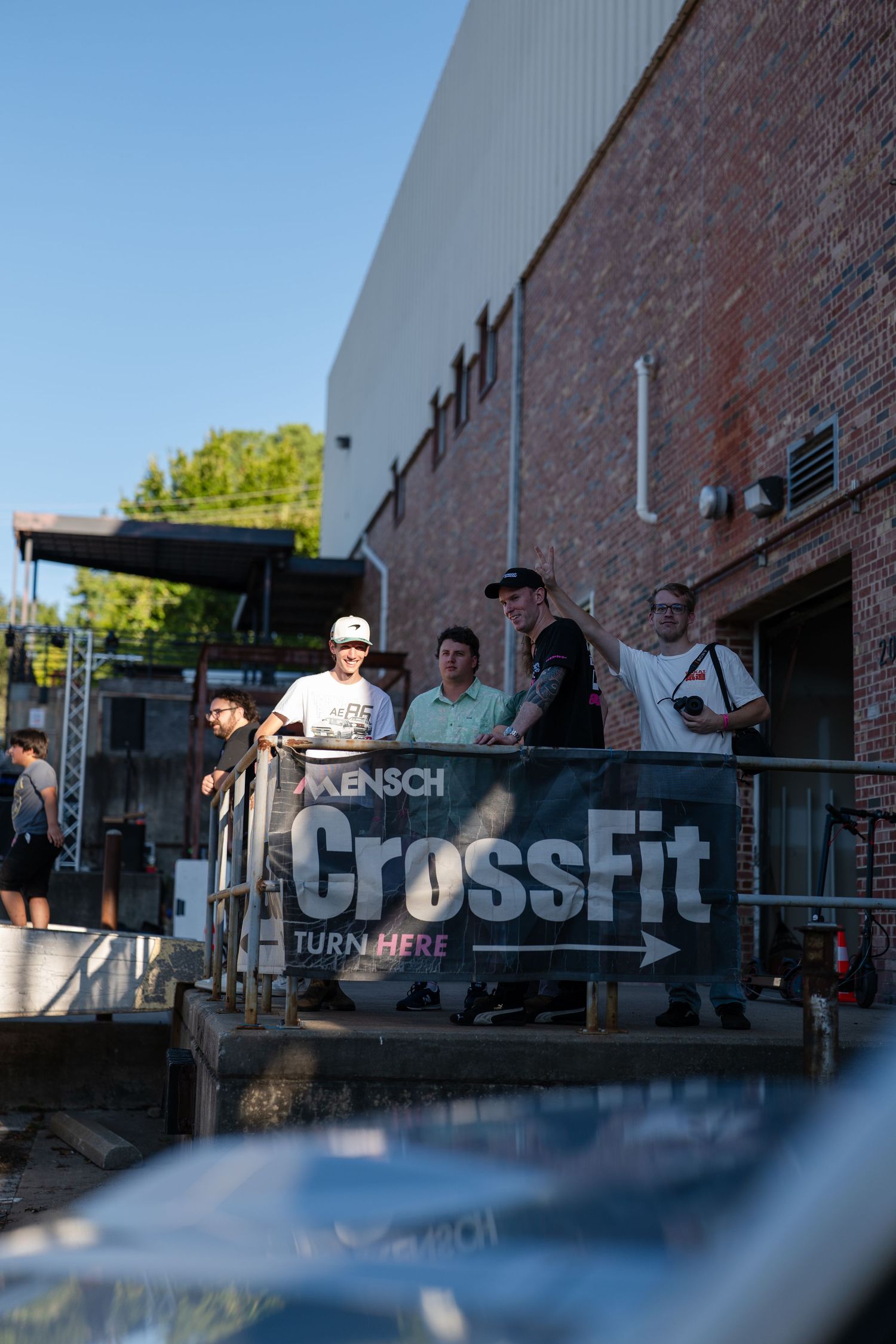Exterior view of a CrossFit gym facility with brick walls and outdoor gathering area.