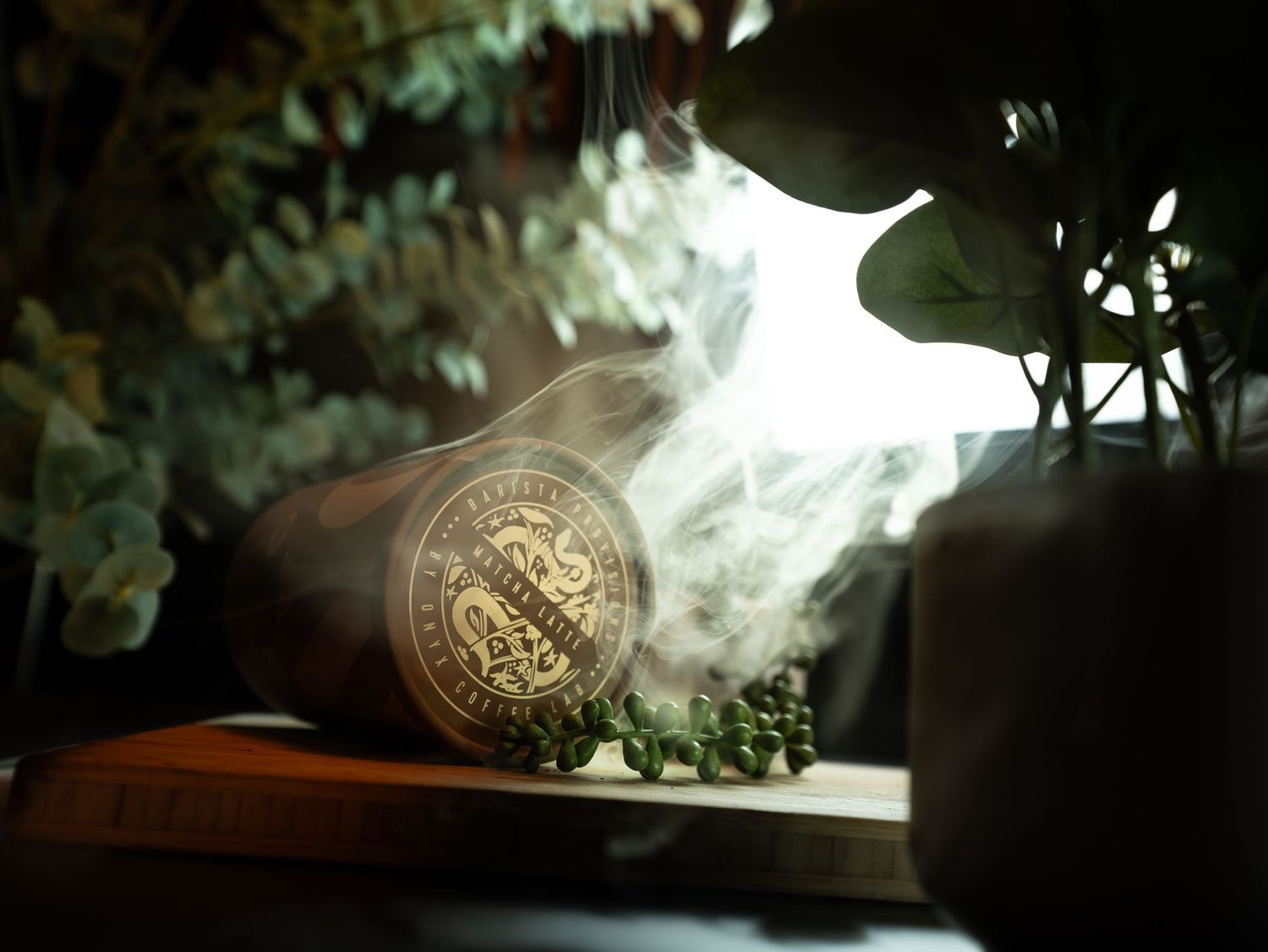 Mystical wooden box with engraved seal emitting smoke, surrounded by green herbs and plants in moody lighting.