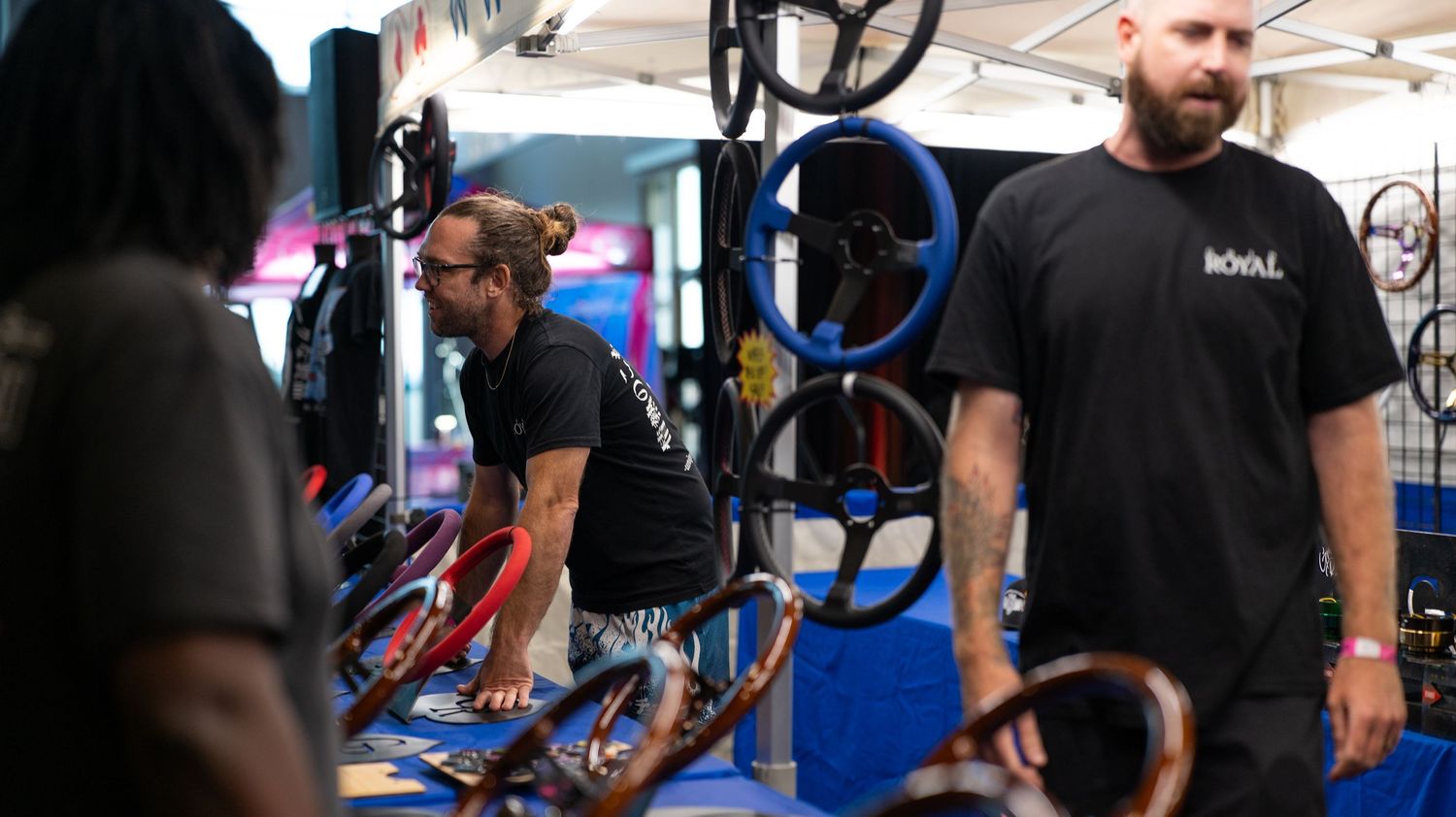 People moving through an indoor event space with bikes and equipment visible.