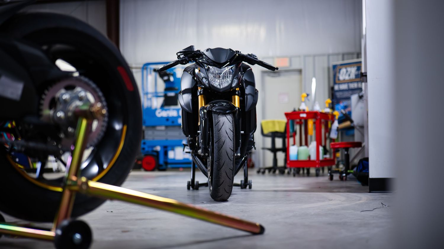 Industrial garage interior with motorcycles and maintenance equipment.