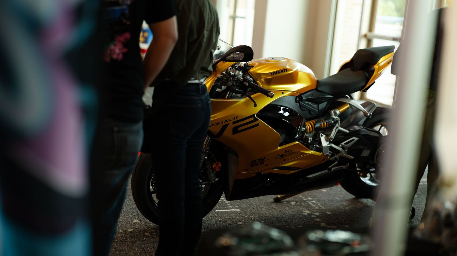 Yellow sports bike and other motorcycles displayed in a showroom setting.