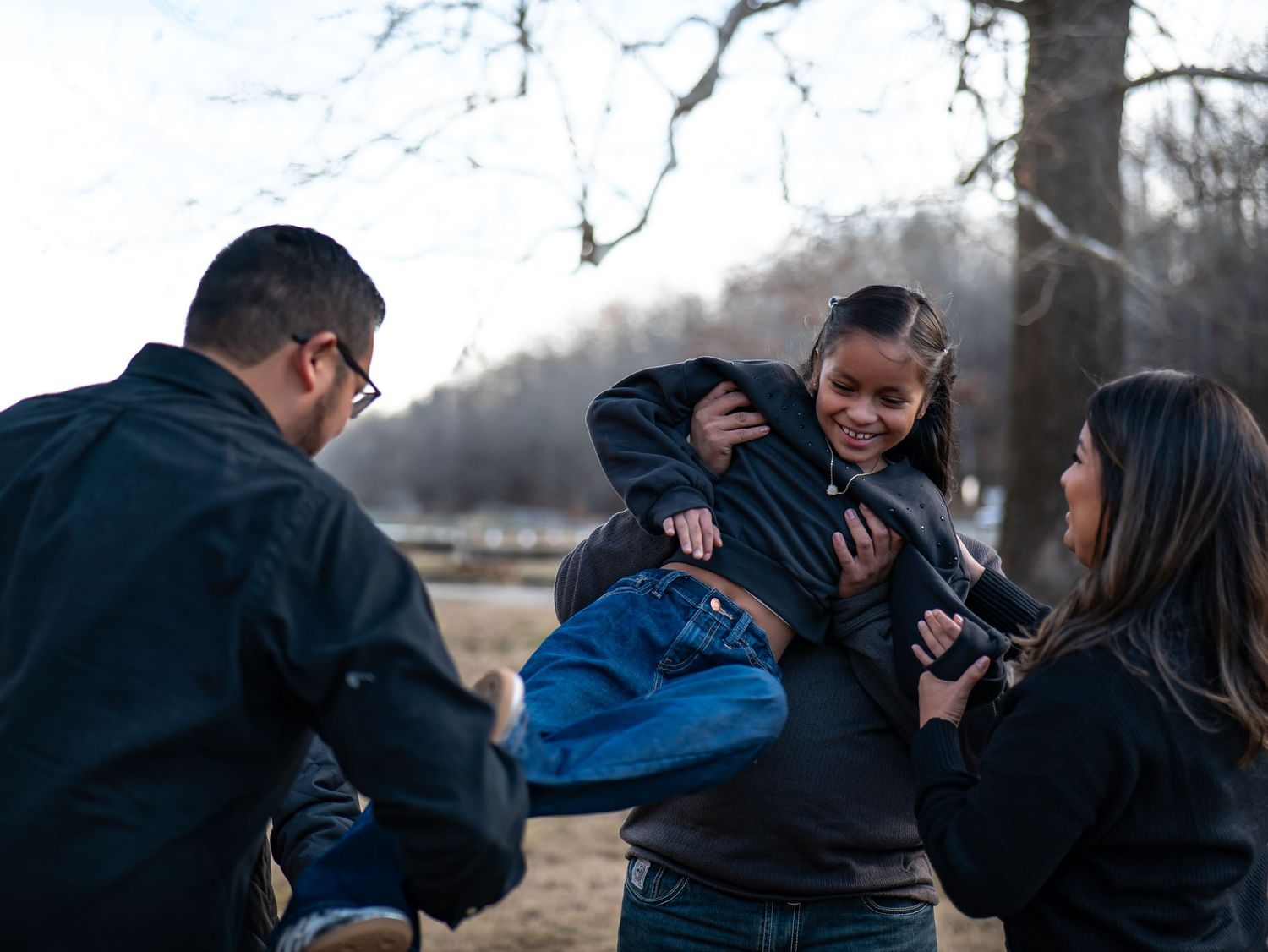 A group of people gather outdoors in winter, sharing a joyful moment together in a natural setting.