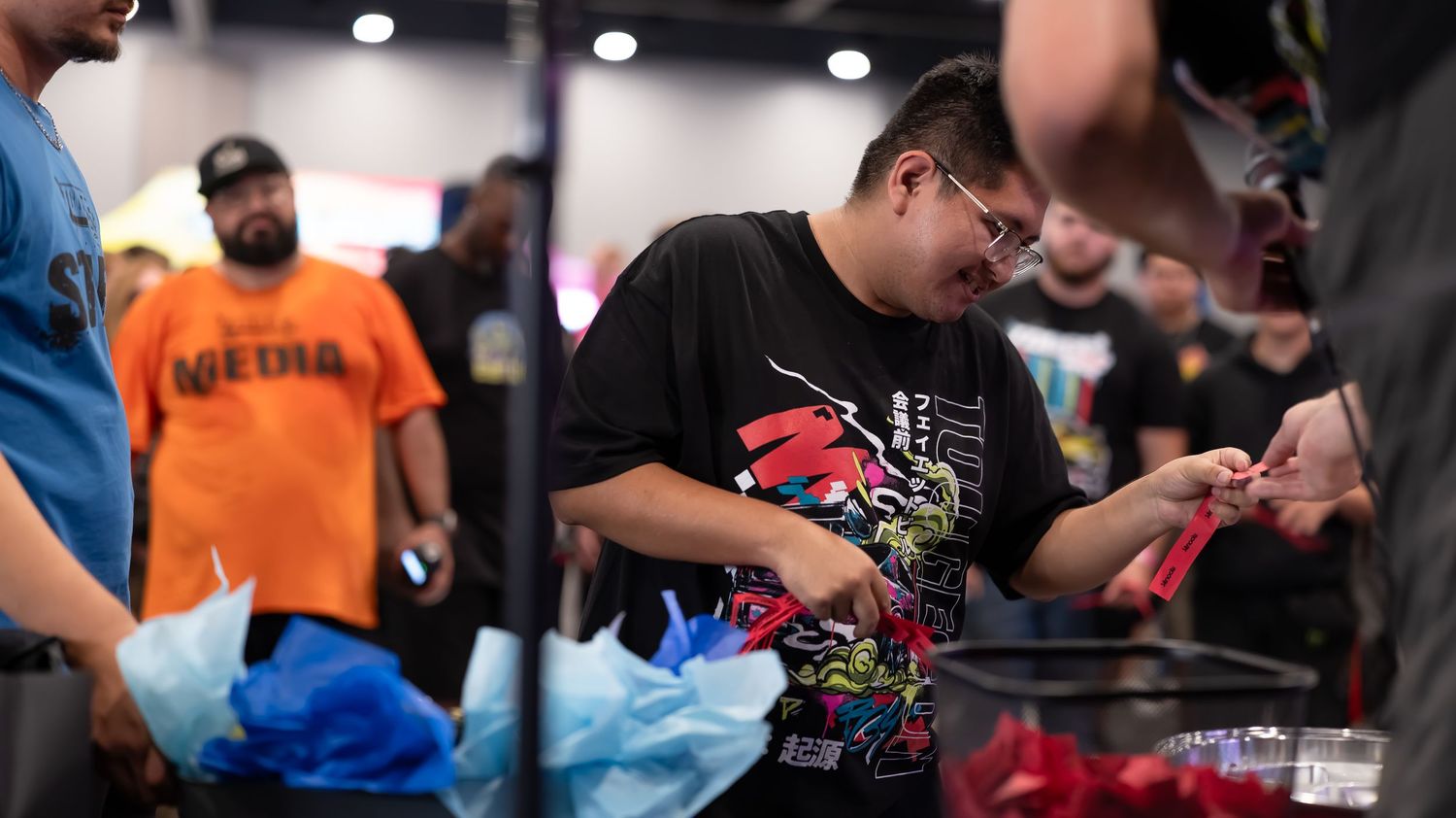 Close-up view of convention attendees browsing gaming merchandise and displays.