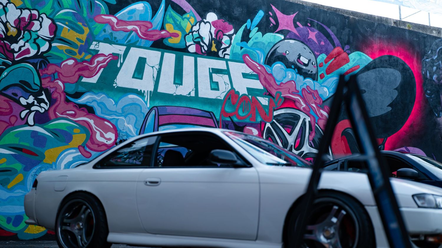 Colorful graffiti art murals decorate walls with vibrant pink and blue designs.