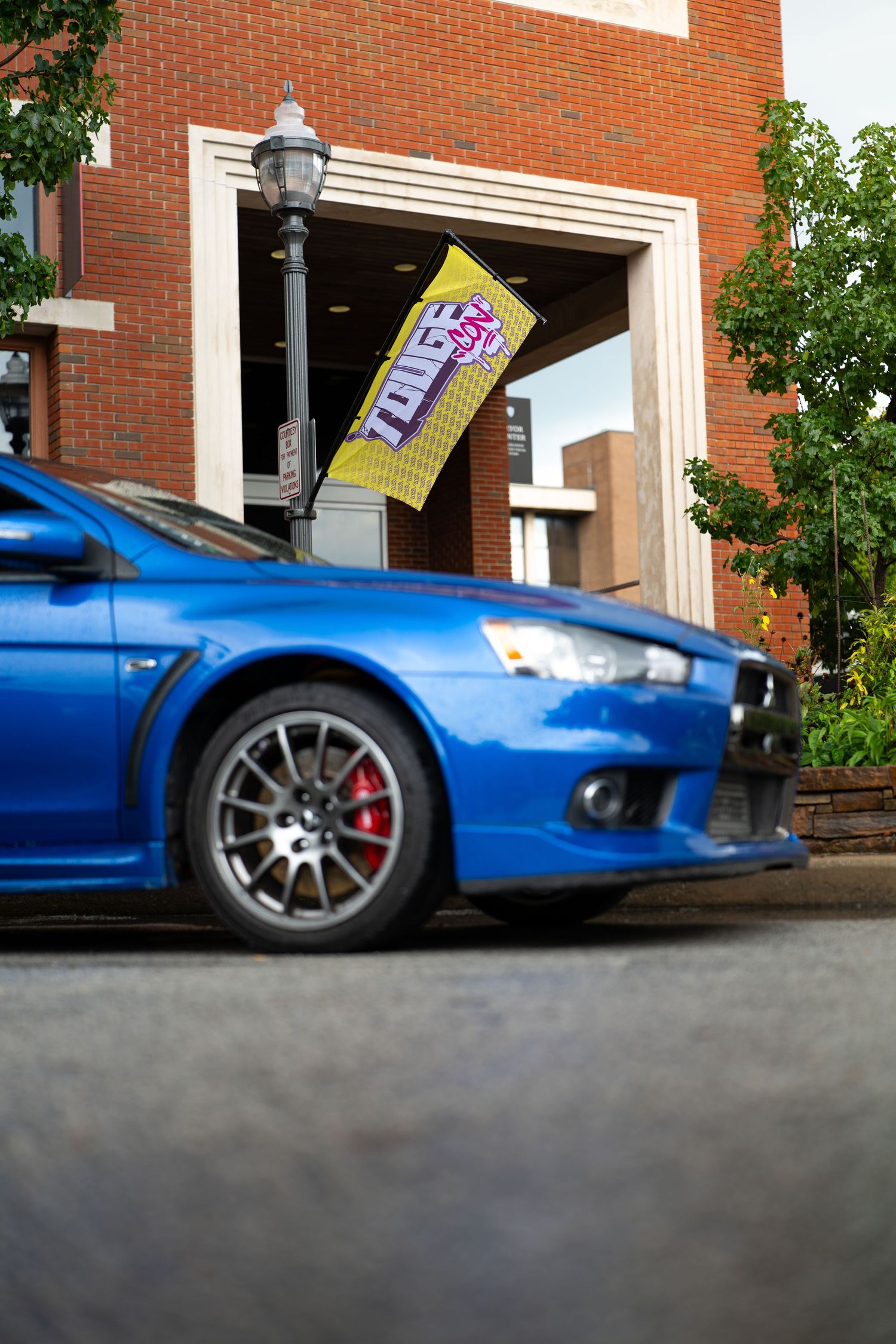Low angle view of a blue sports car parked near a brick building.