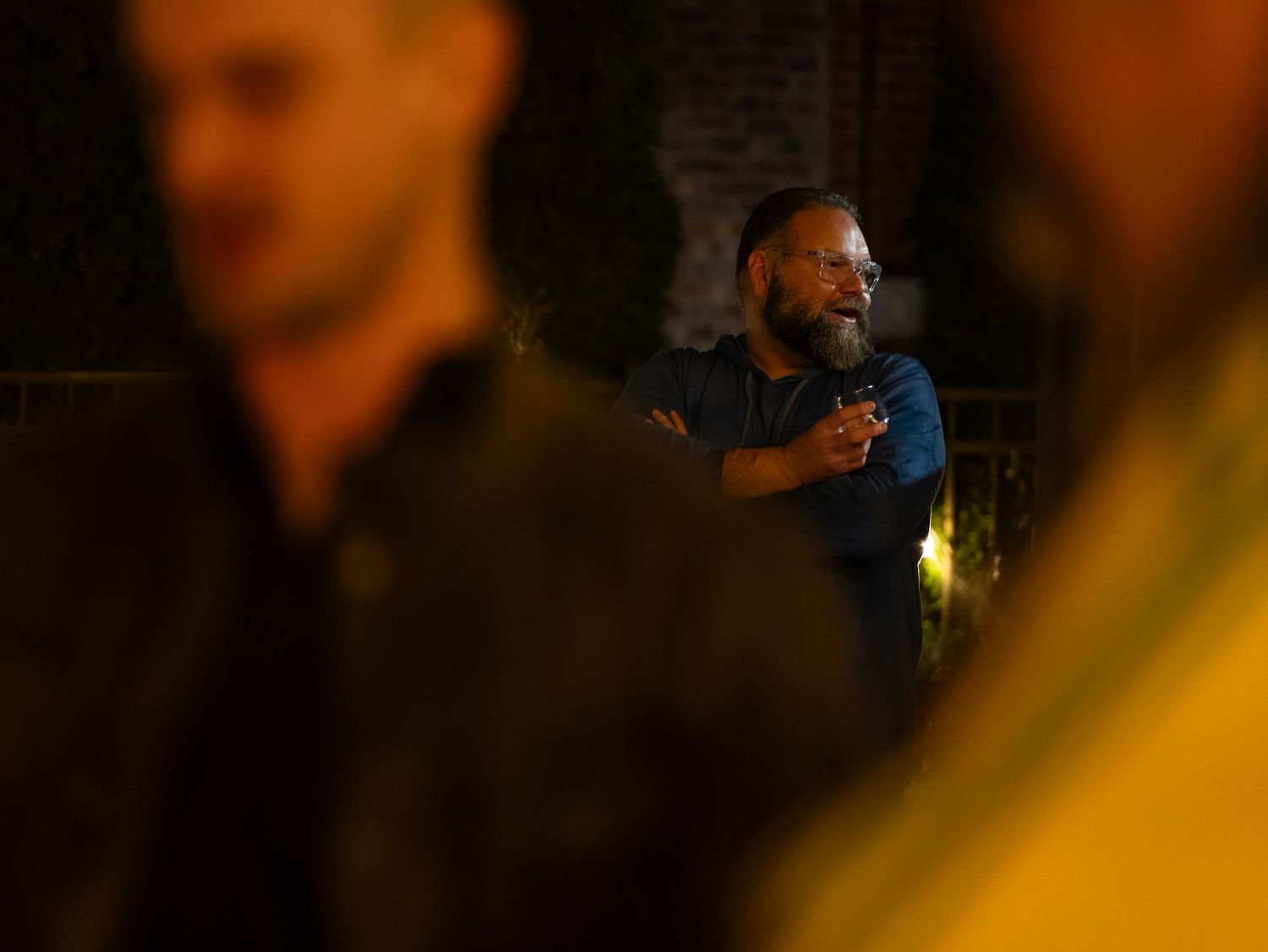 A series of blurred, dimly lit photos showing dark silhouettes against a warm yellow background.