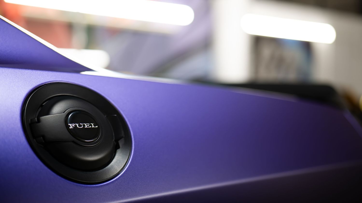Close-up detail shot of a purple car's exterior panel and trim.