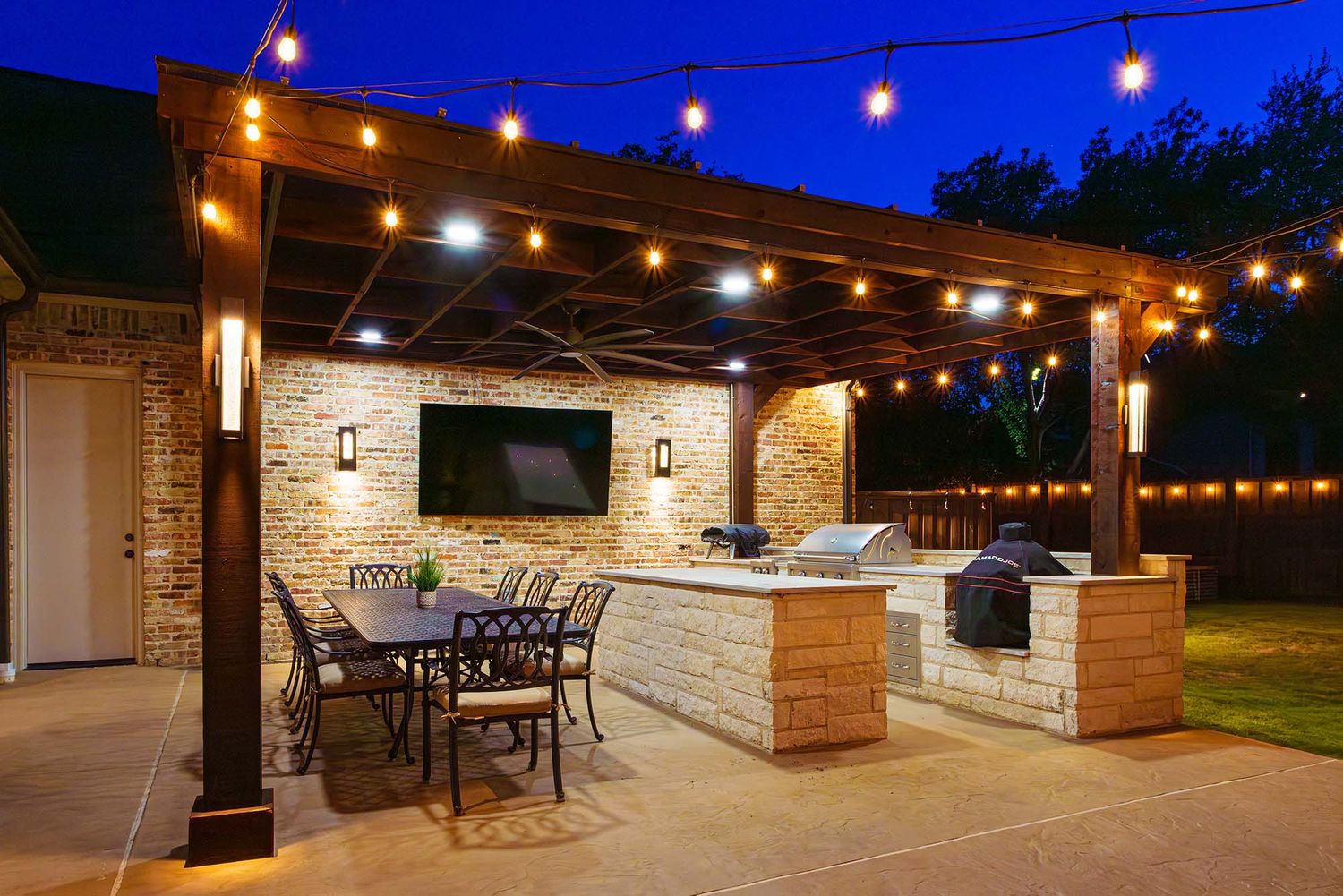 Outdoor patio area with string lights and stone walls creating an elegant evening ambiance.
