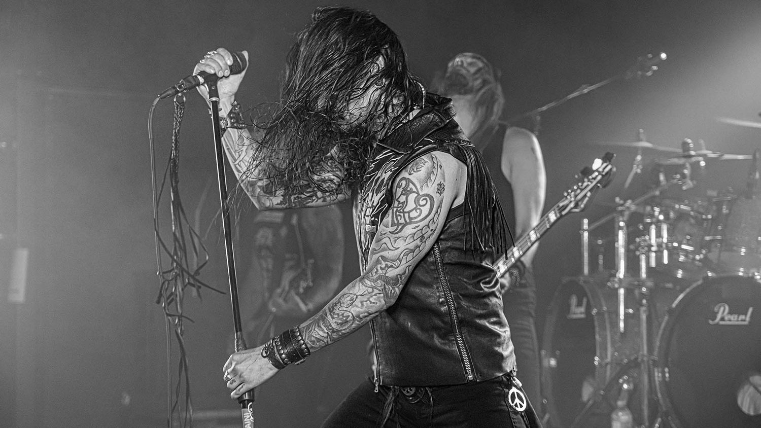 Black and white concert photography showing musicians performing with dramatic stage lighting.