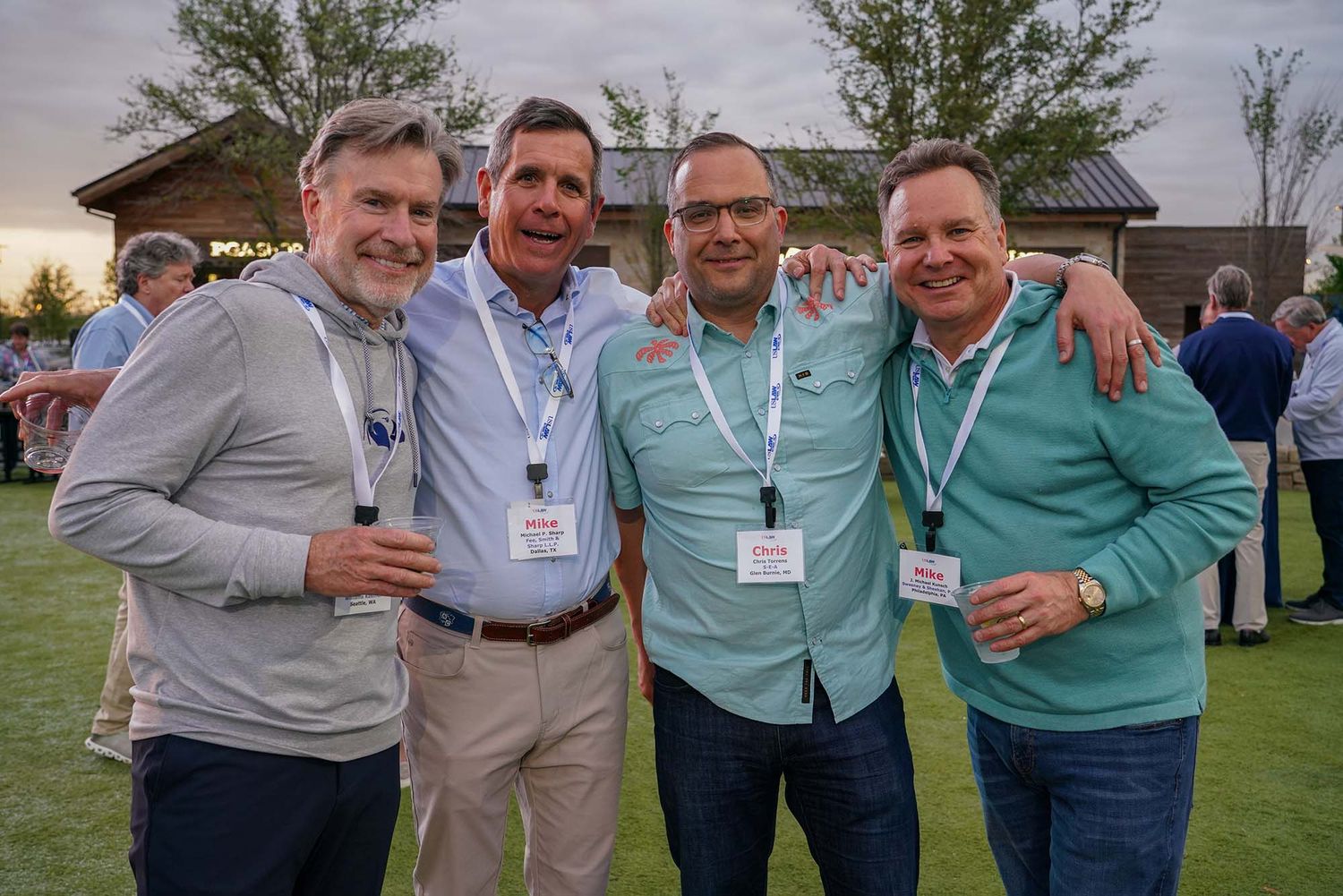 Group of professionals enjoying casual conversation at an outdoor networking event.