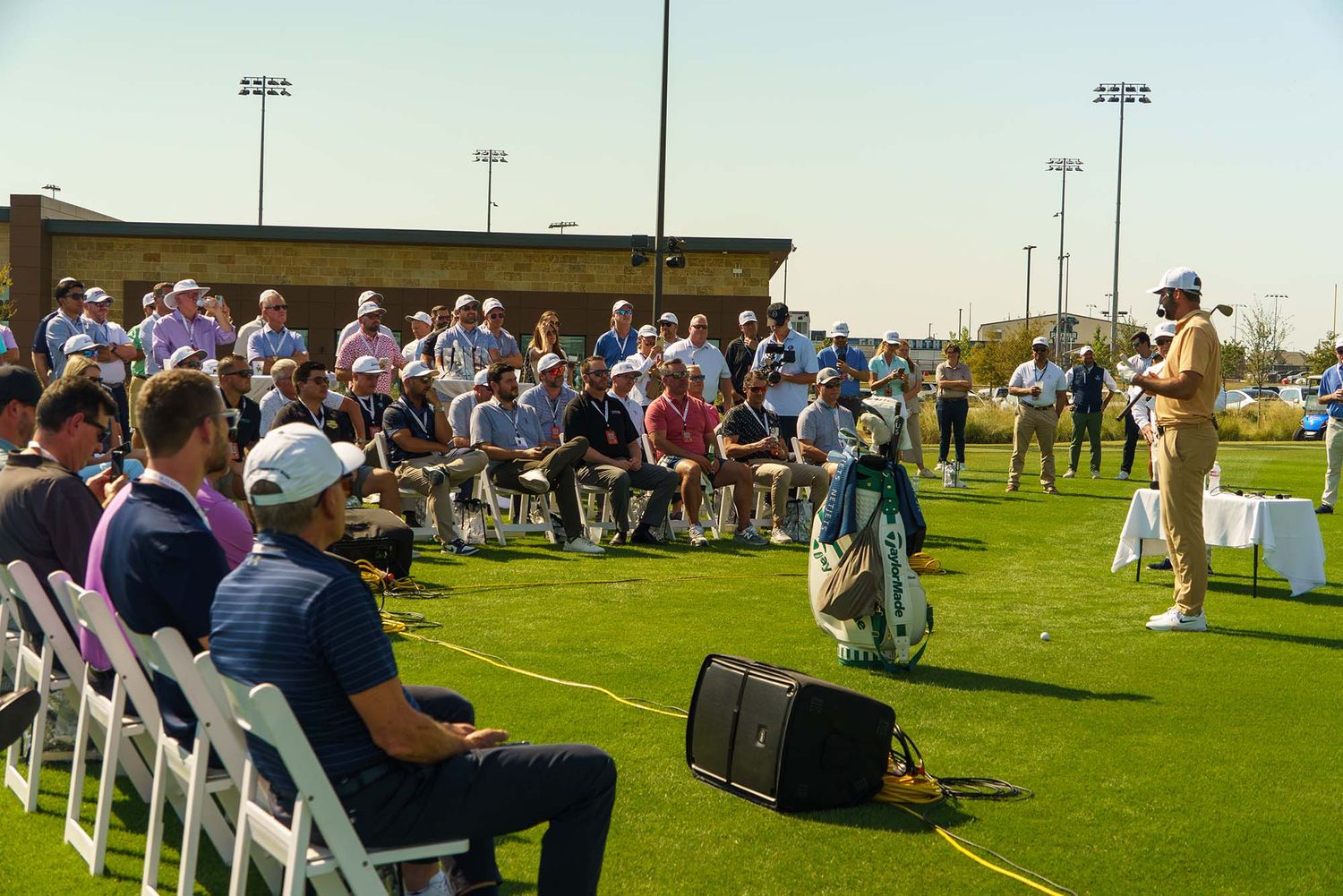 Rows of white chairs set up on a grassy field for an outdoor gathering.