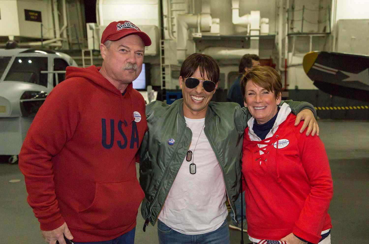 Group wearing red and casual clothing gathered inside what appears to be an industrial or warehouse setting.