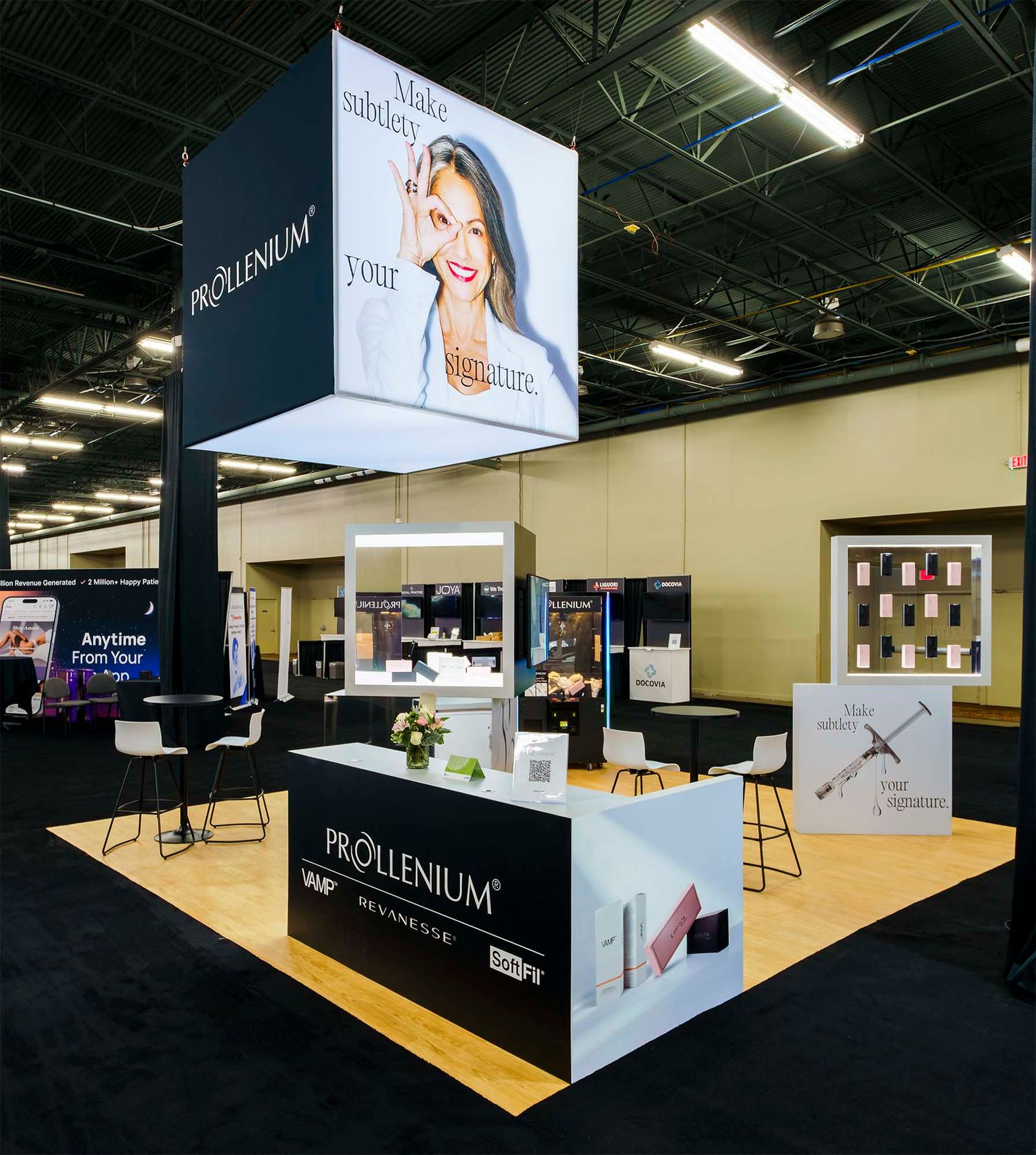Large exhibition booth setup with white displays and branding in a spacious convention center.
