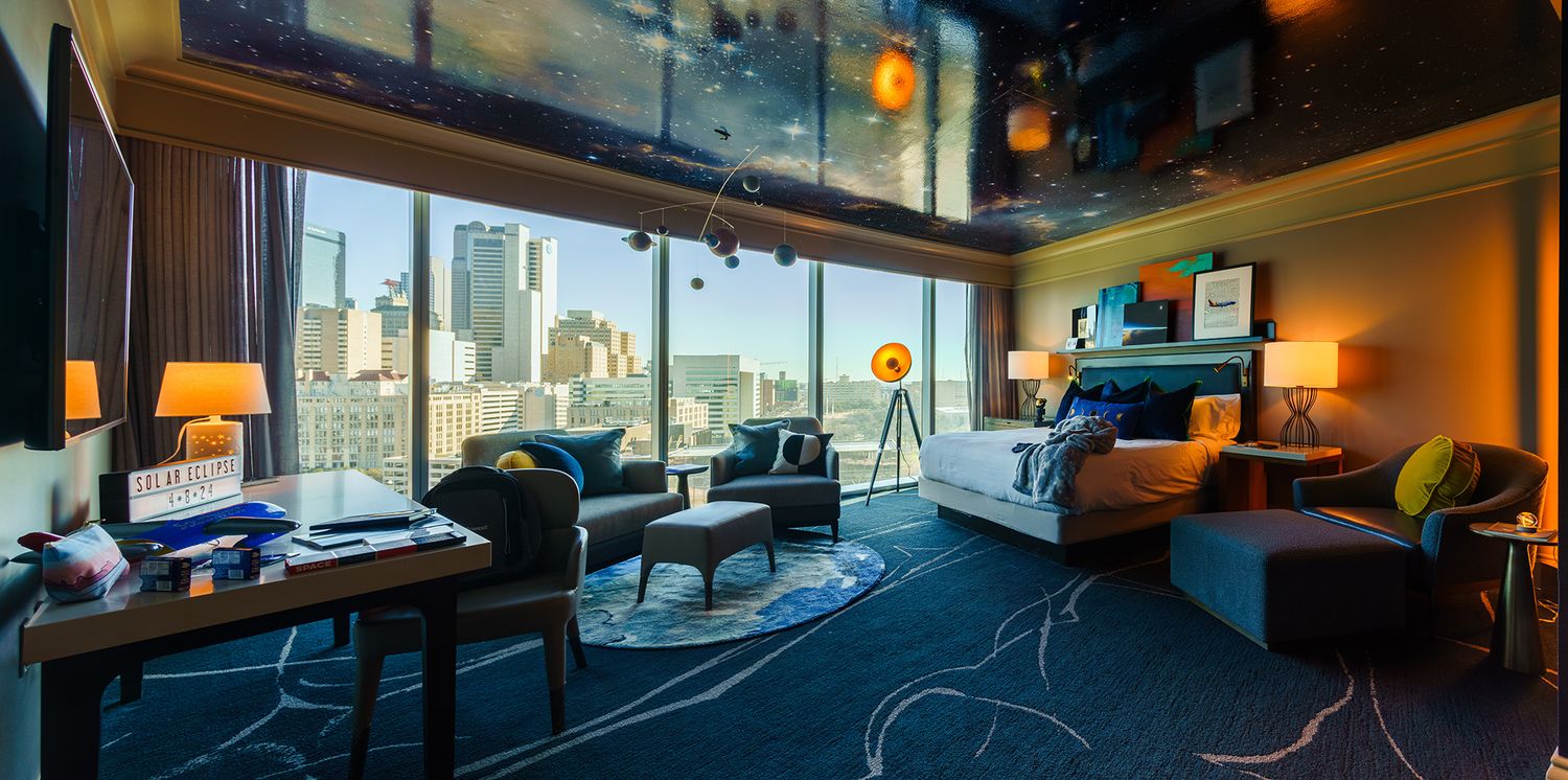 Panoramic windows in a modern hotel room offering sweeping city views.