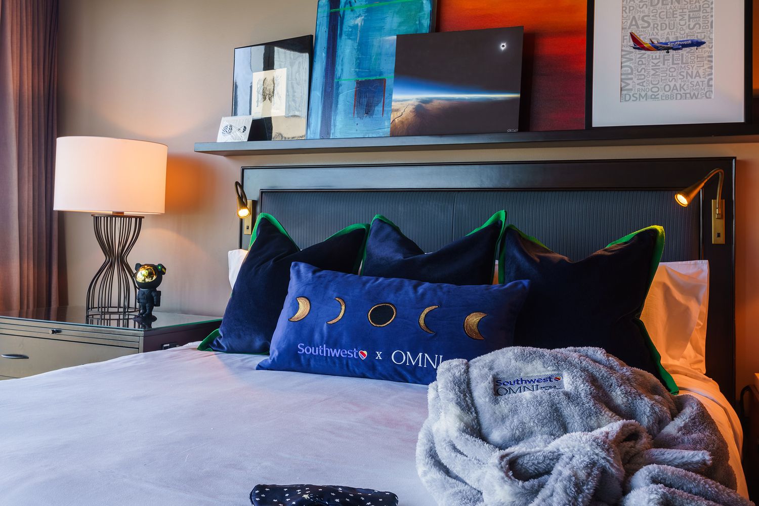 Cozy hotel room interior with blue accents and modern furnishings under mood lighting.