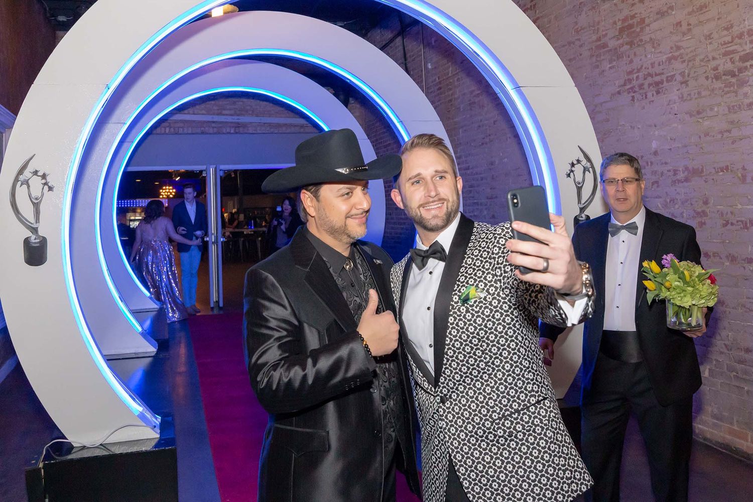 Guests enjoying themselves at an upscale event with dramatic blue lighting and architectural details.