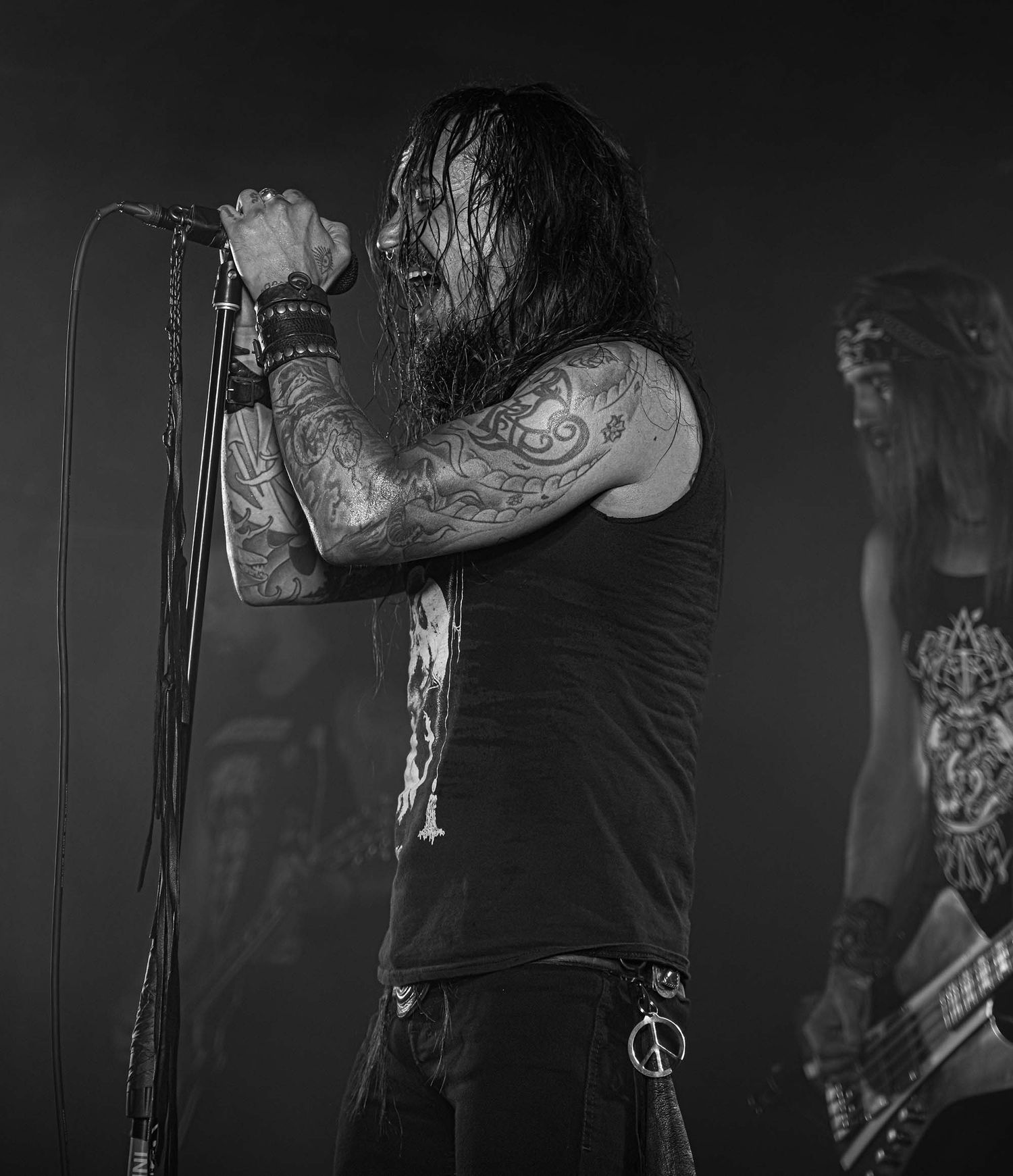 Black and white photo of musician performing on dark stage.