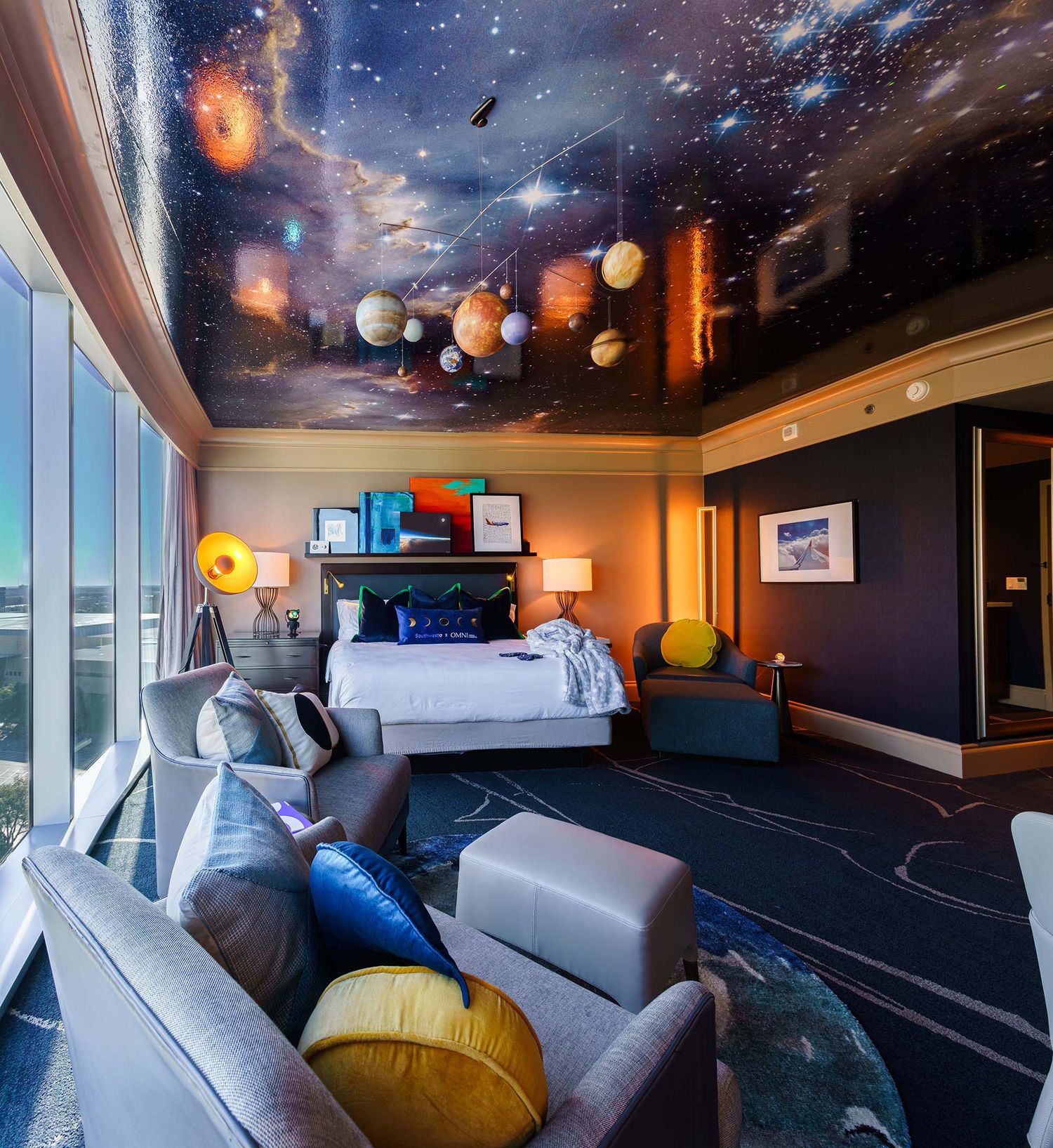 Modern hotel room with cosmic-themed ceiling design featuring twinkling lights and galaxy patterns.