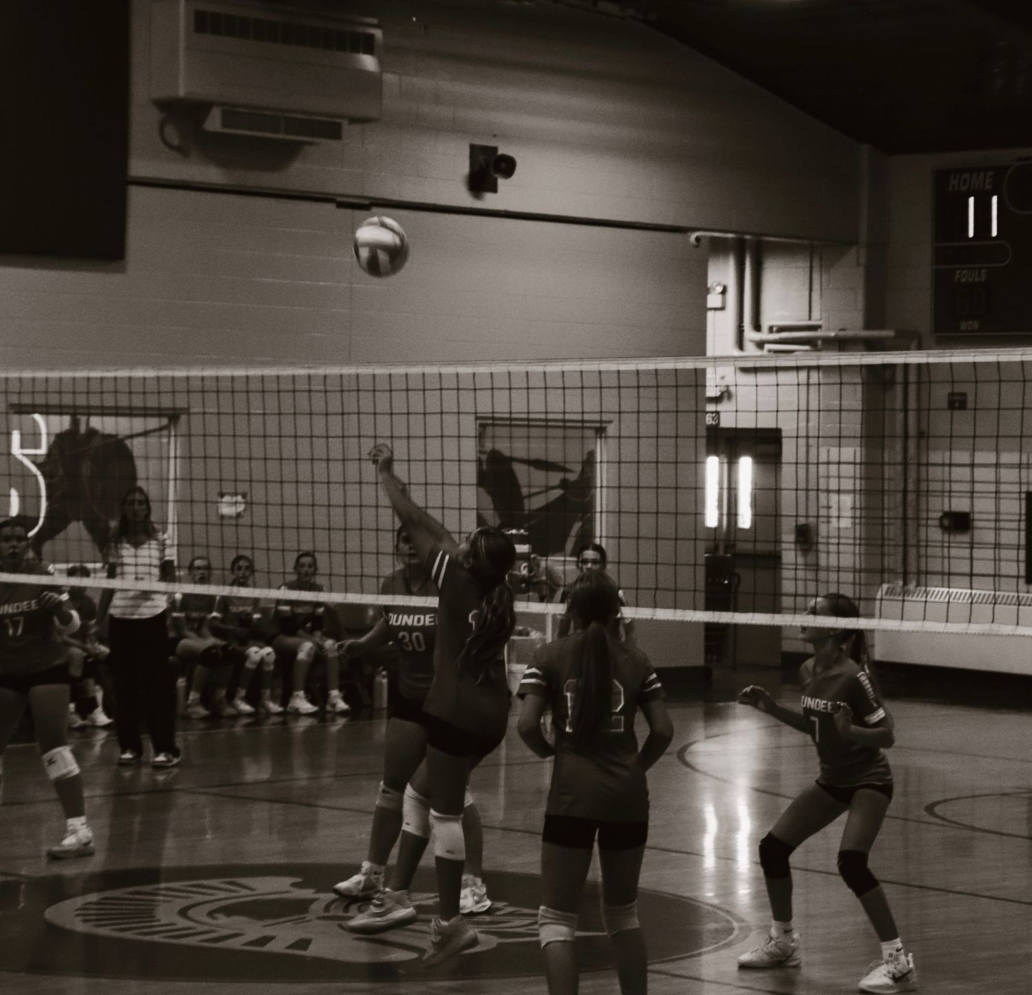 Hitting the volleyball in black and white.