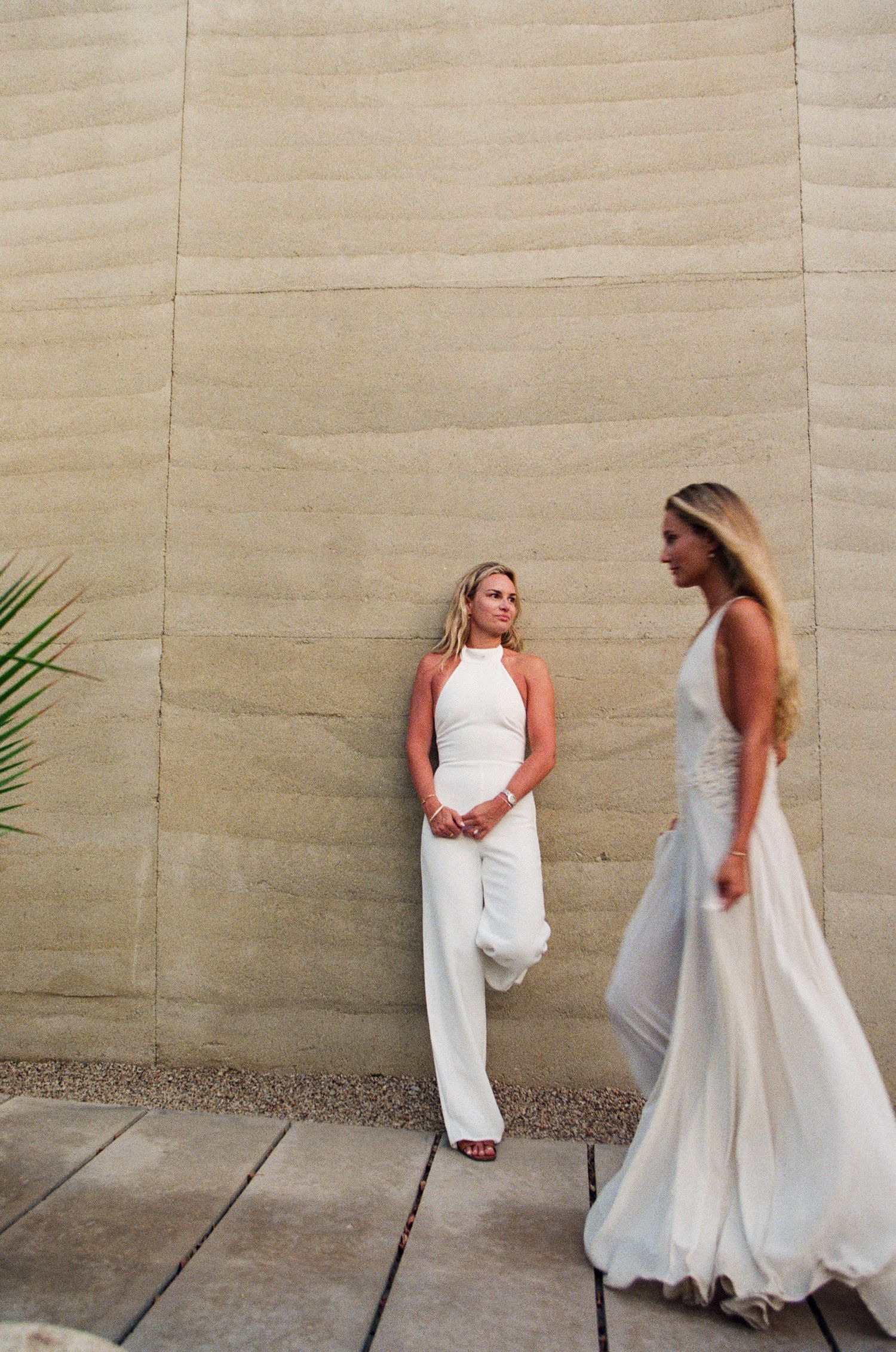 Editorial engagement portrait of LGBT+ couple against a concrete wall at Acre Resort.