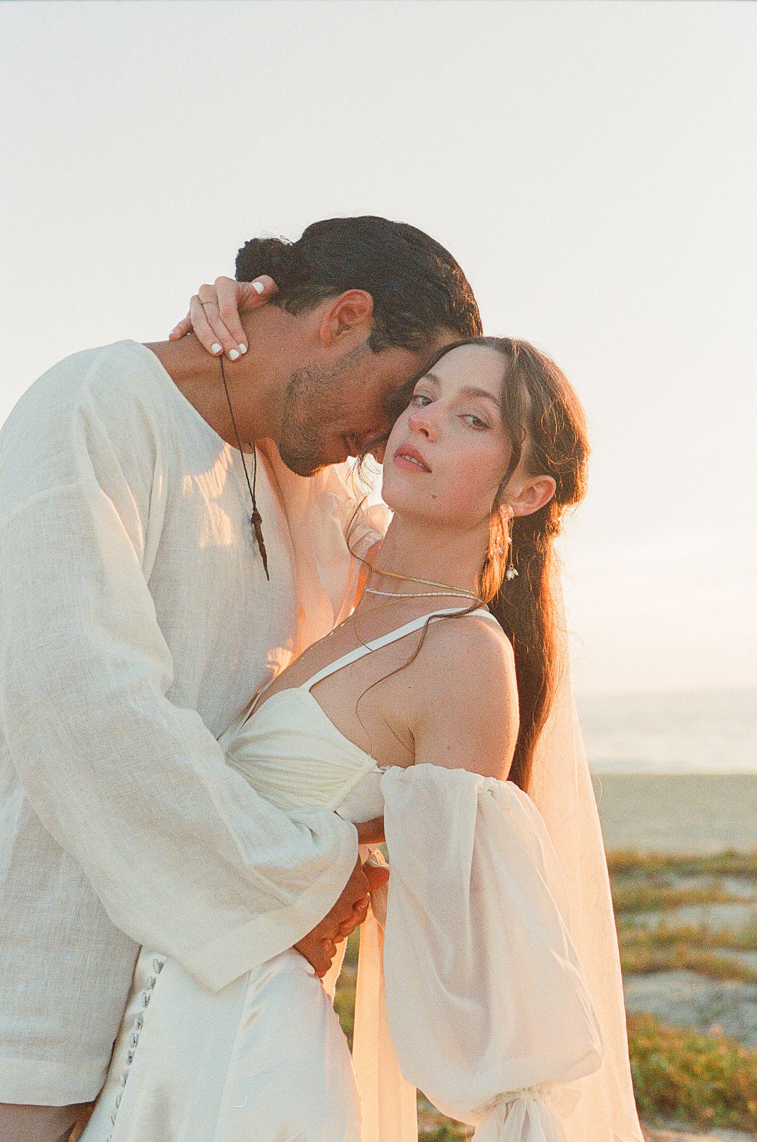 Newly eloped couple sharing an intimate embrace at sunset in Todos Santos