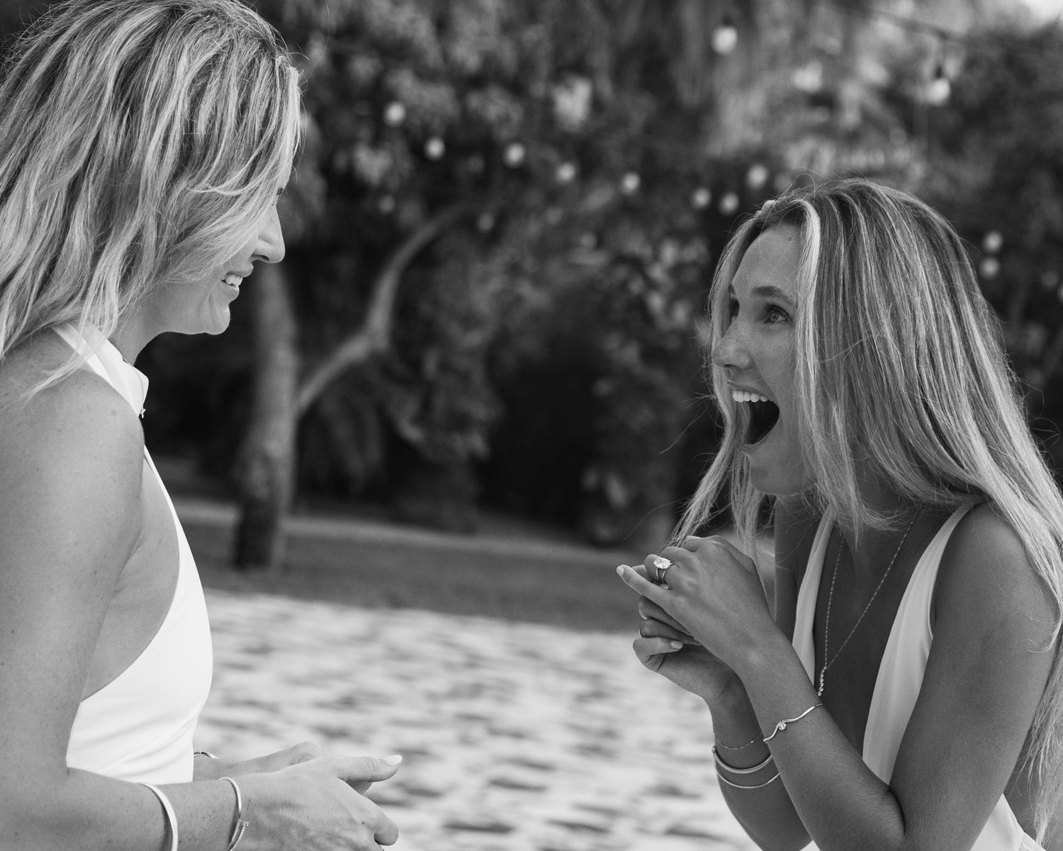 Black and white portrait of couple smiling big after just being proposed to at Acre Resort.