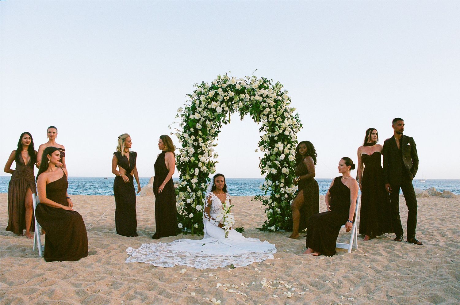 Bride with bridal party on the beach in front of ceremony arch Cabo San Lucas.