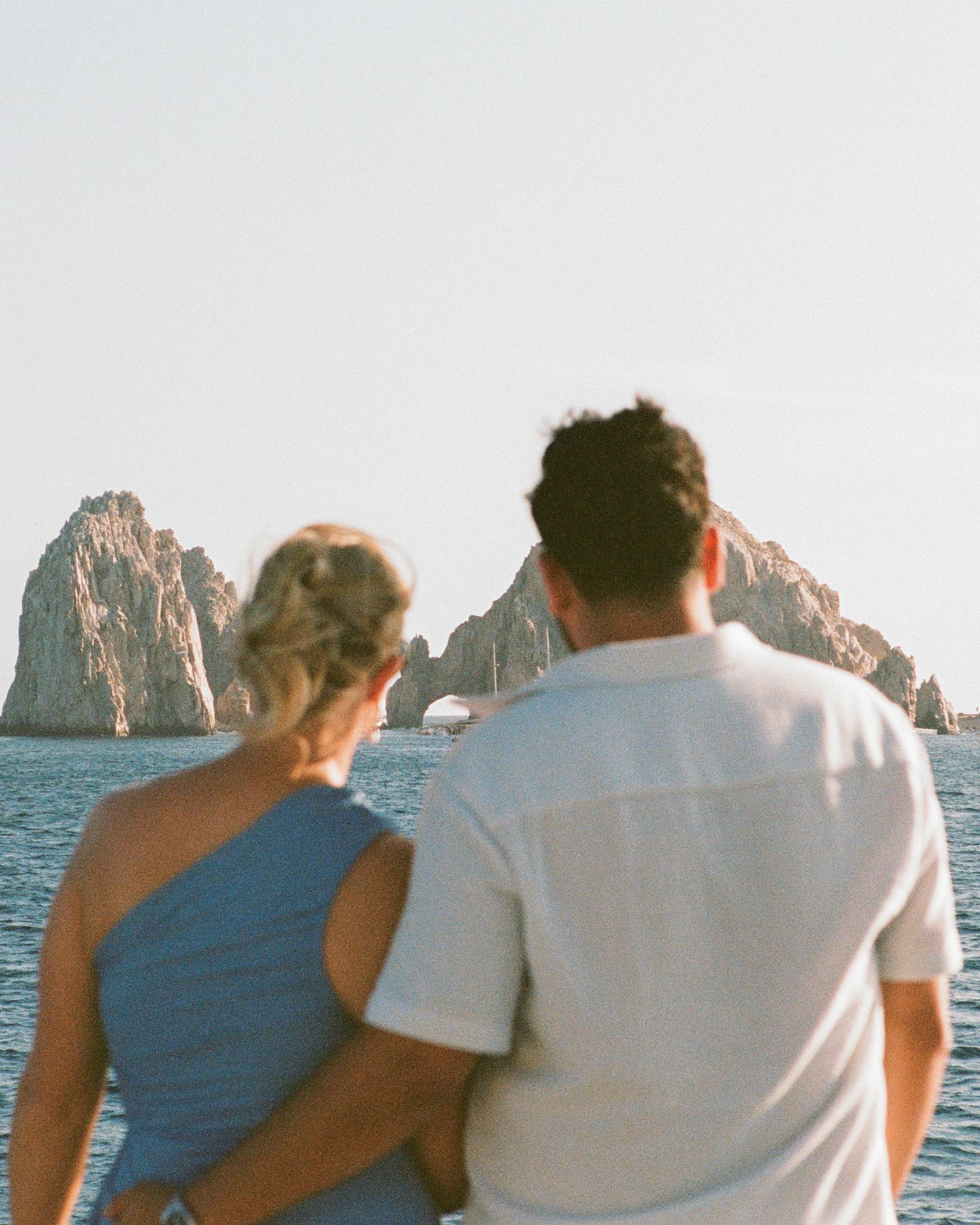 The couple looking over the Cabo San Lucas arch on a sunset boat cruise.