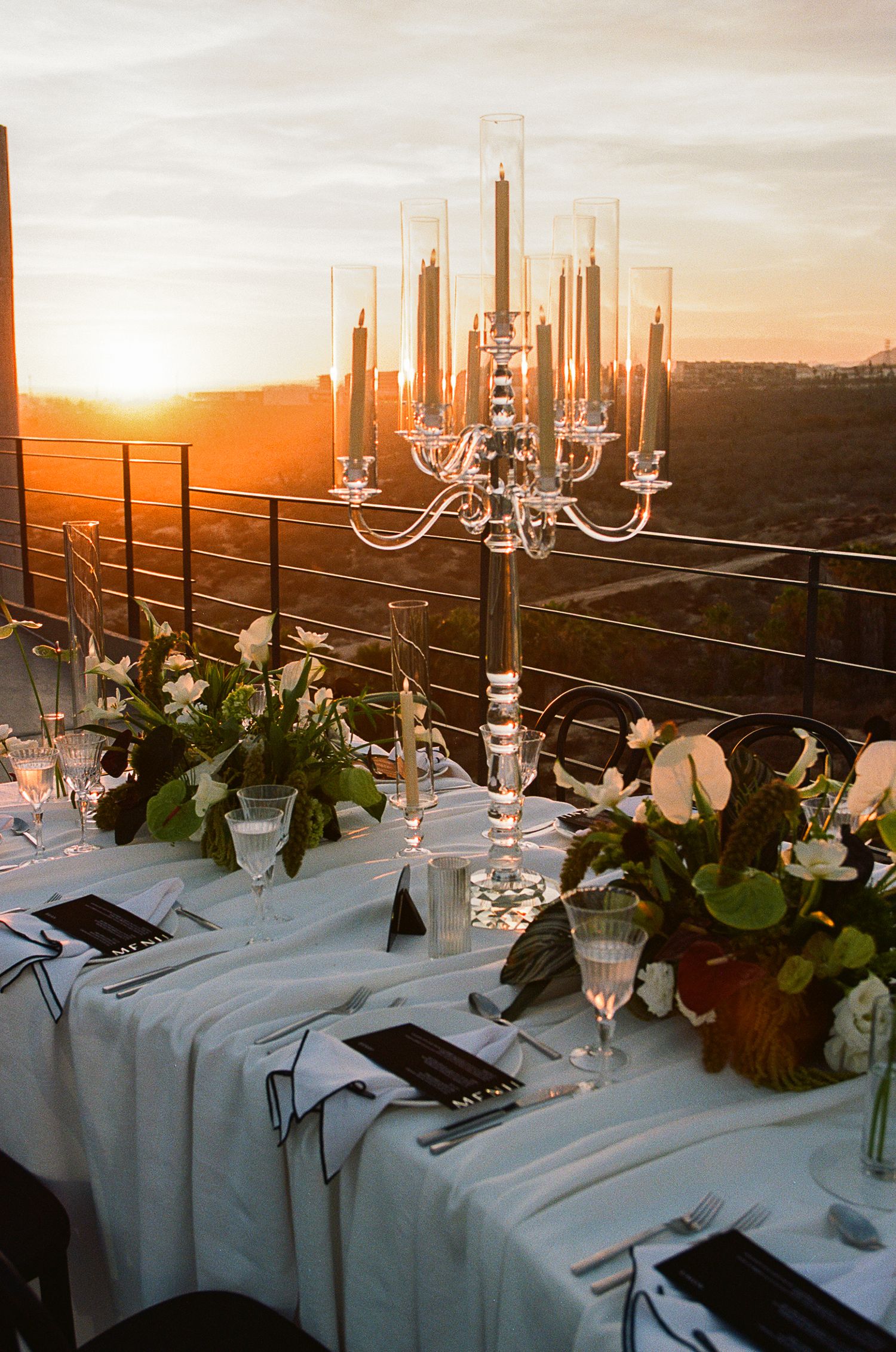 Romantic wedding reception table with sunset over desert background at The Cape, a Thompson Hotel, Cabo San Lucas.
