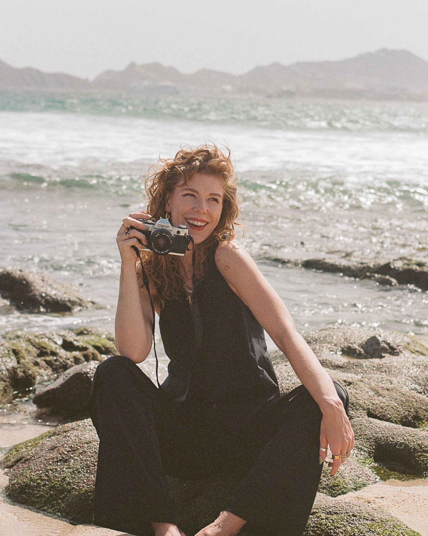Los Cabos wedding photographer Zoey Marchiney holding her camera at The Cape, a Thompson Hotel.