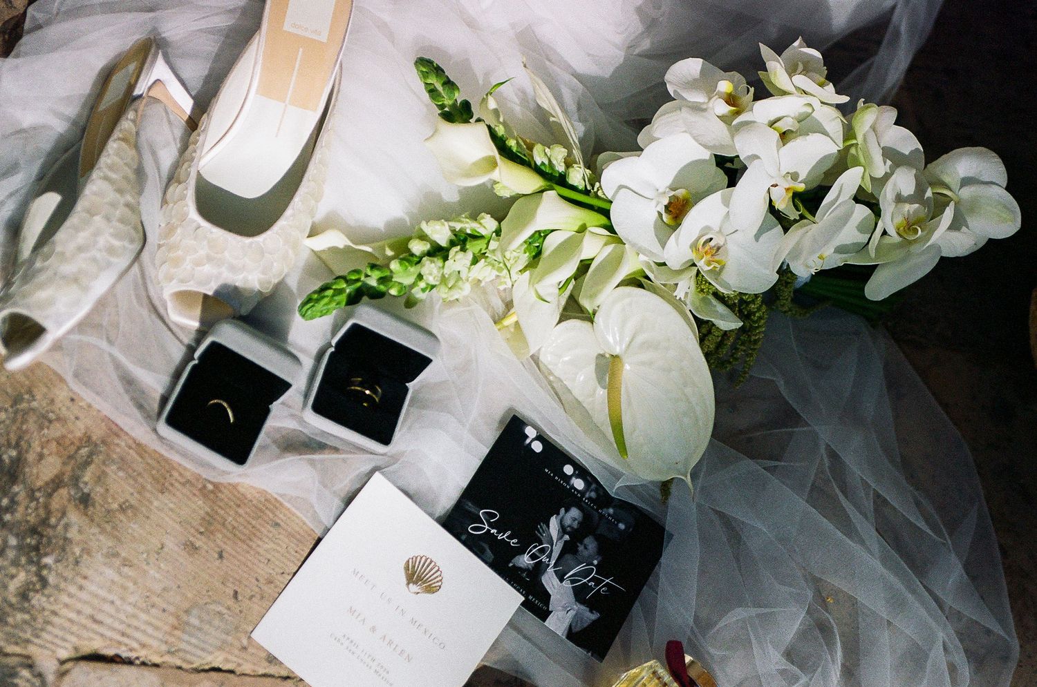 Wedding bouquet, wedding high heels and rings set with the brides veil and invitation suite.