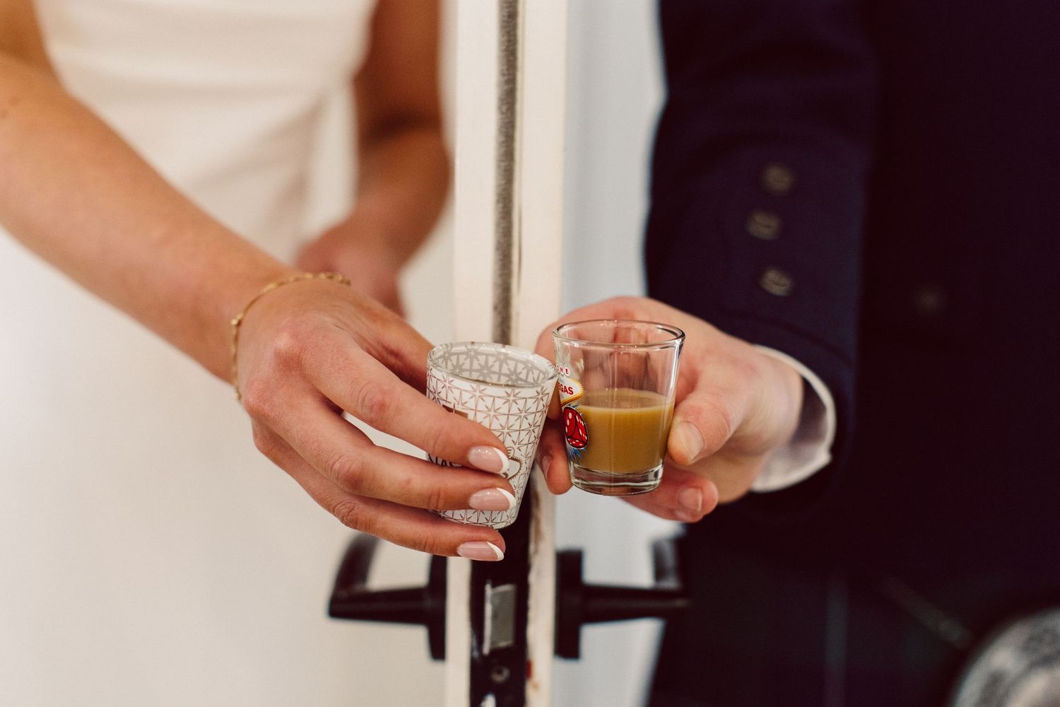 A collection of hands holding various cocktail glasses and beverages in a bar setting.