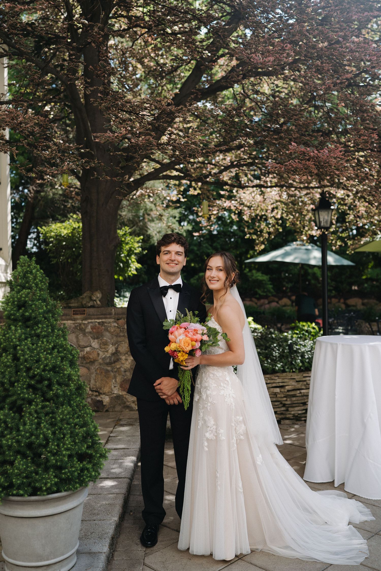 Bride and groom embracing outdoors on their wedding day in Michigan, photographed in a timeless documentary style that is inspired by film.