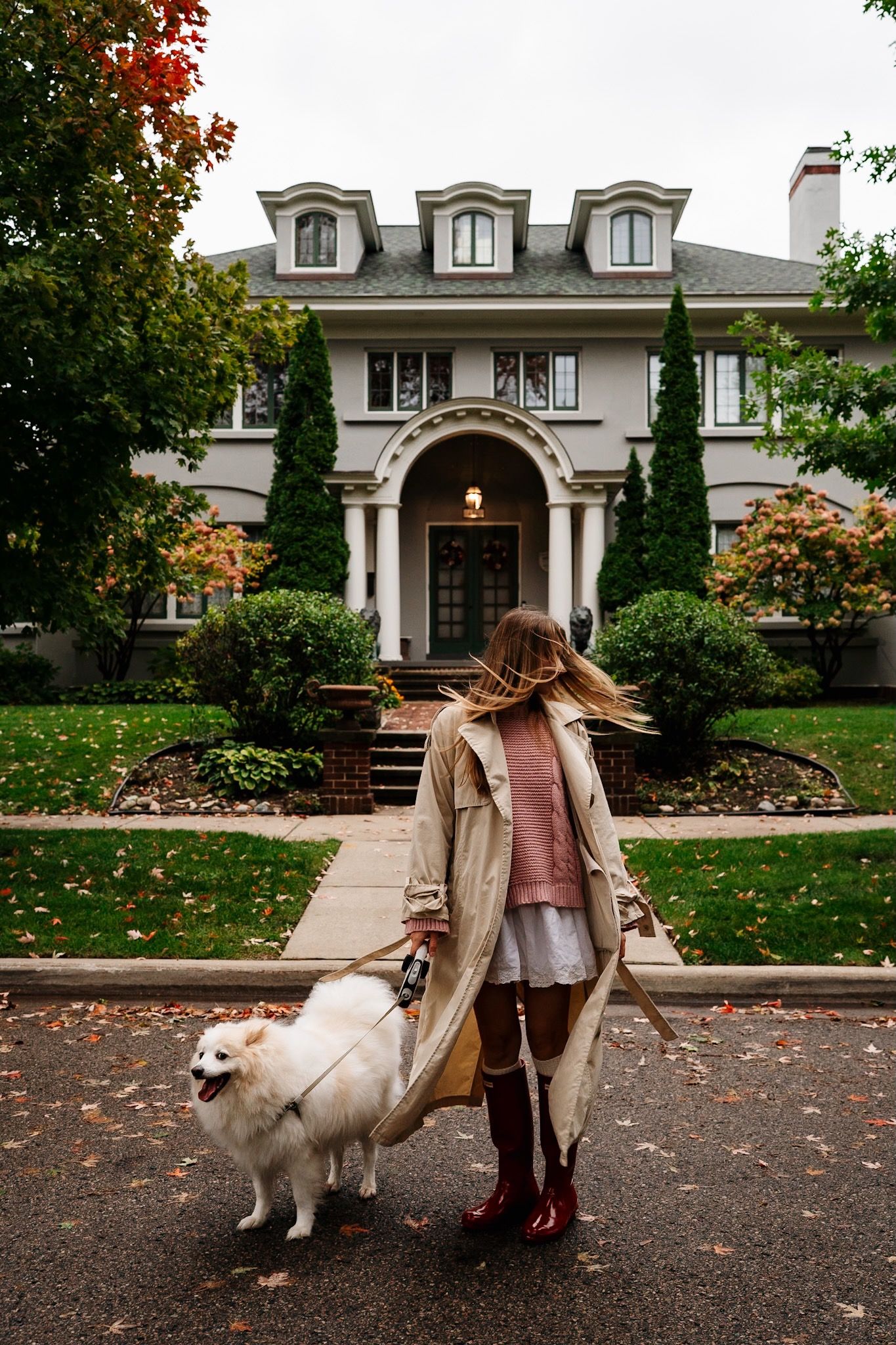 Woman and her dog sitting together outside a historic Heritage Hill home.