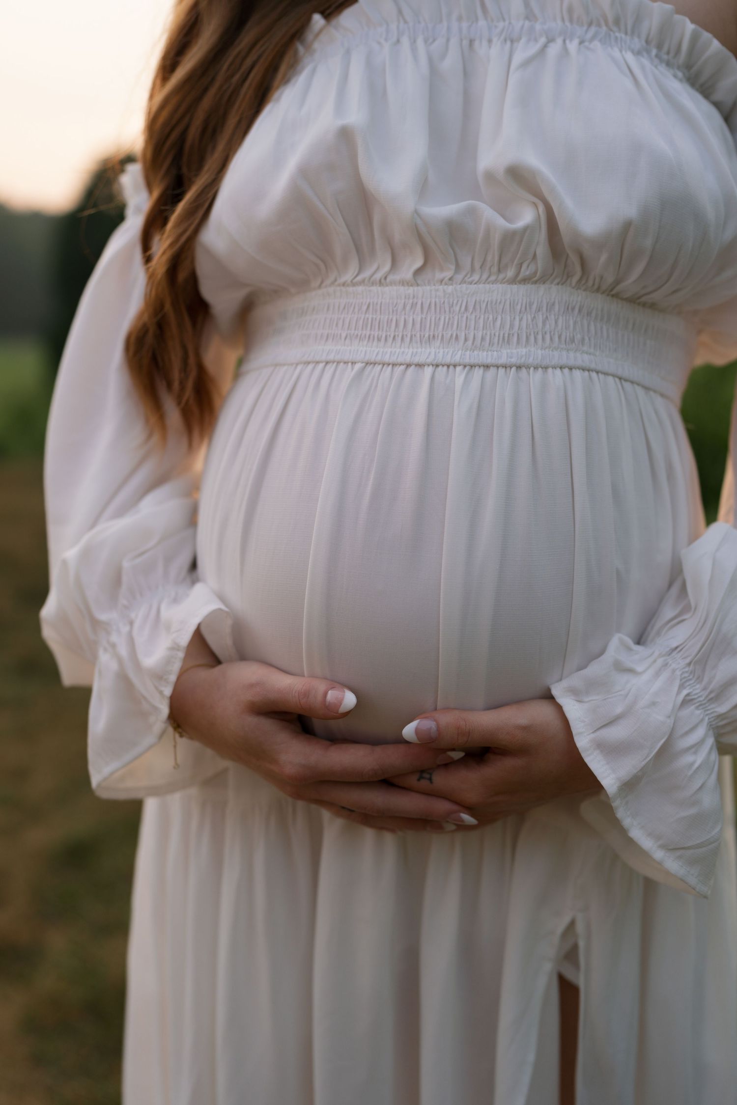 Expectant parents sharing a quiet embrace during their maternity session at Highlands Prairie.