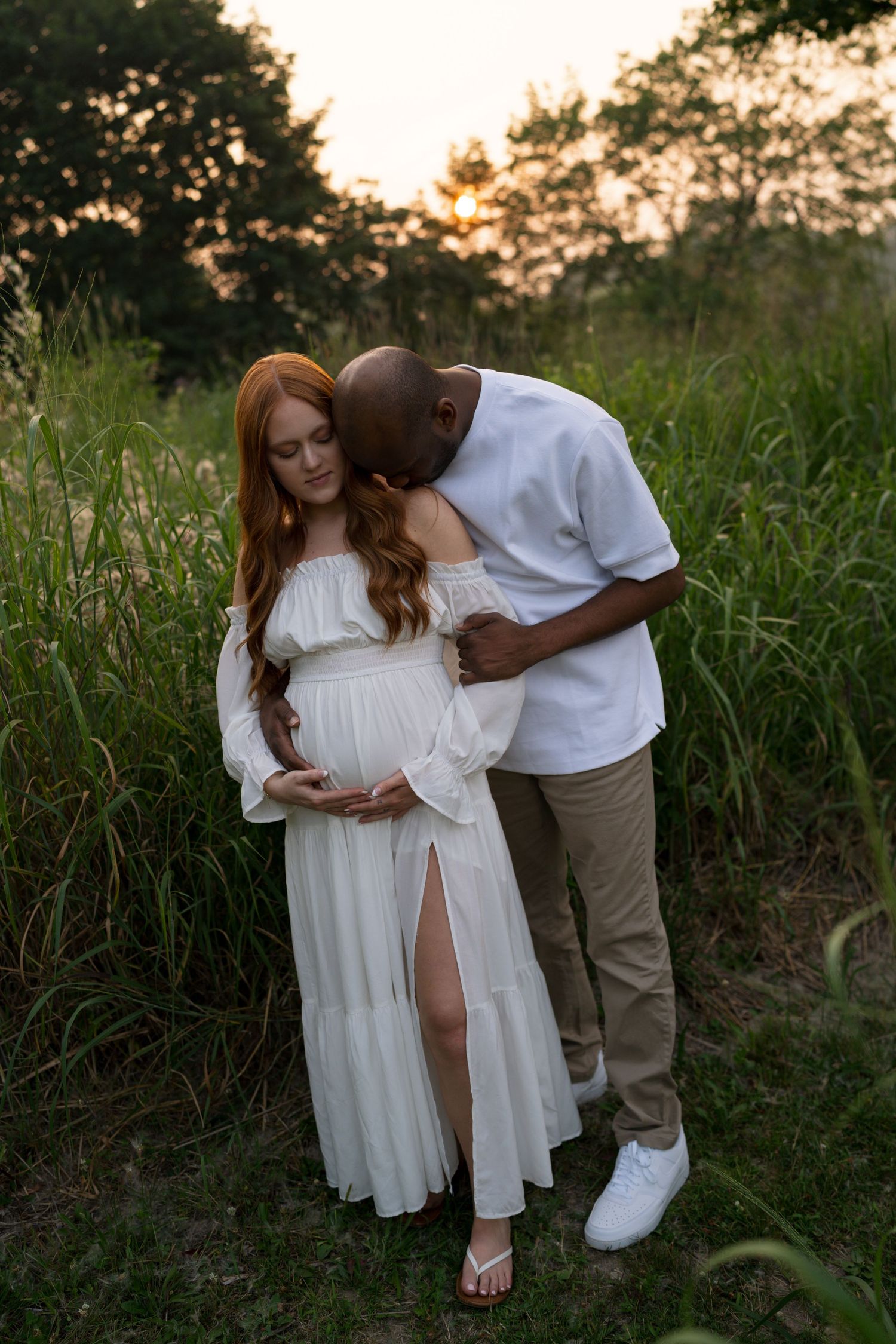 Expectant parents walking together through the prairie at Highlands Prairie.